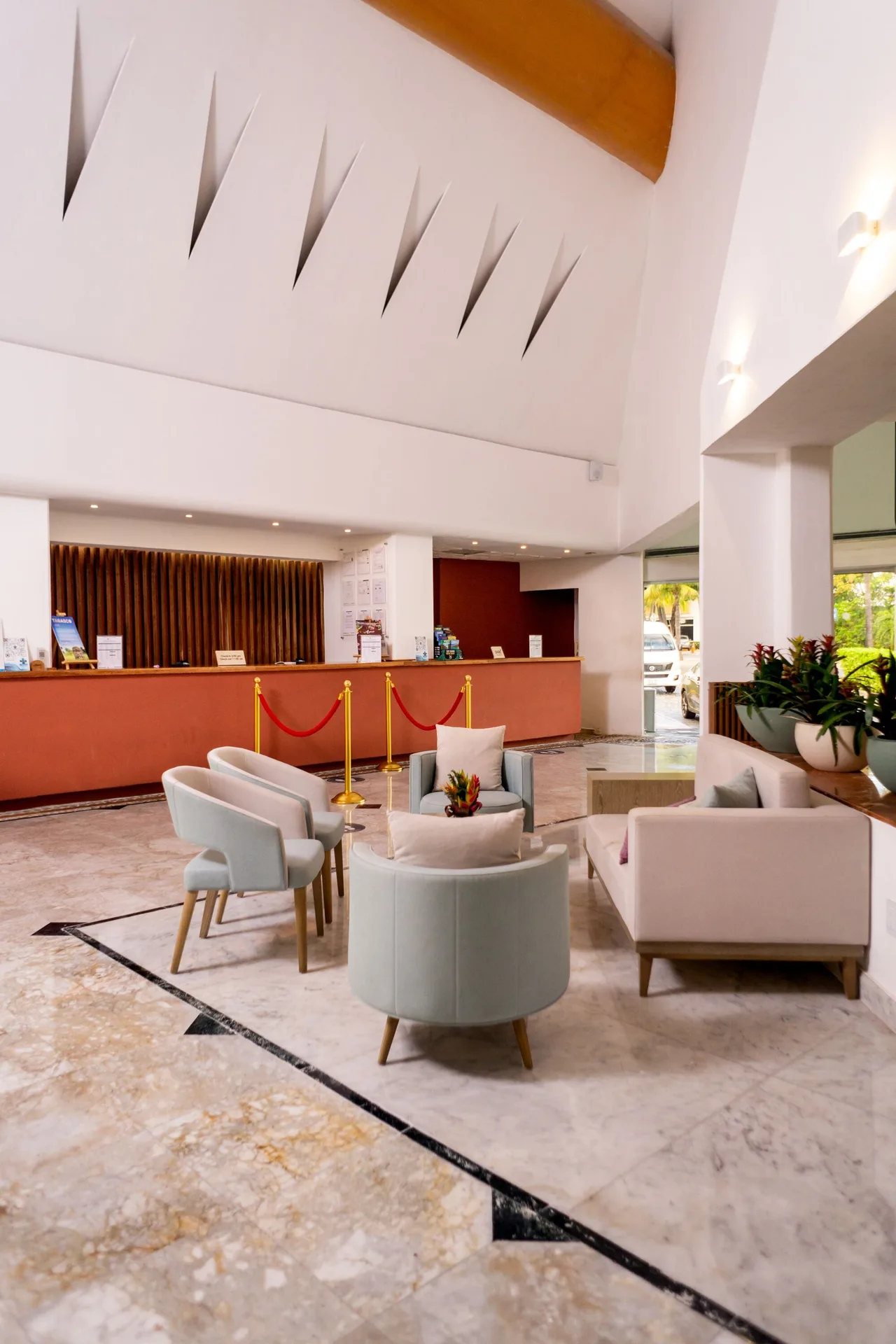 Lobby lounge with reception desk, armchairs, and high ceiling at Sunset Marina Resort & Yacht Club.