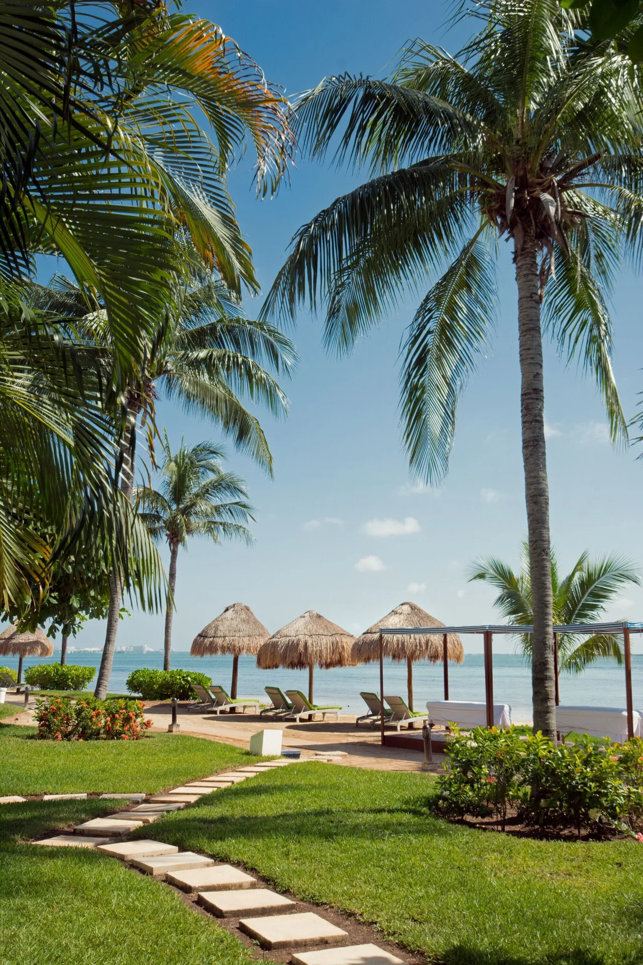 Palm garden with palapa shades by the water at Sunset Marina Resort & Yacht Club.
