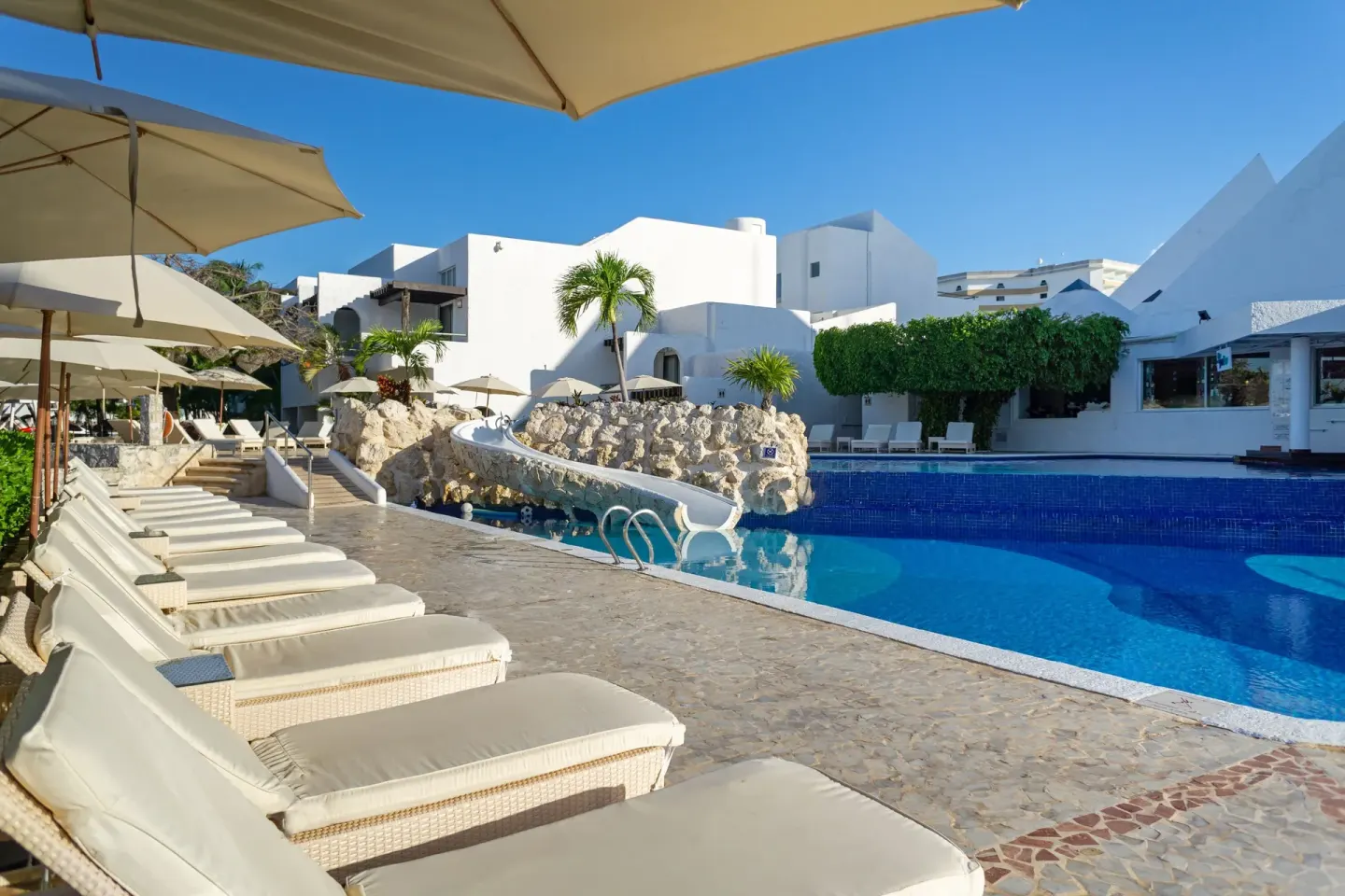 Pool deck with cushioned loungers and umbrellas at Sunset Marina Resort & Yacht Club.