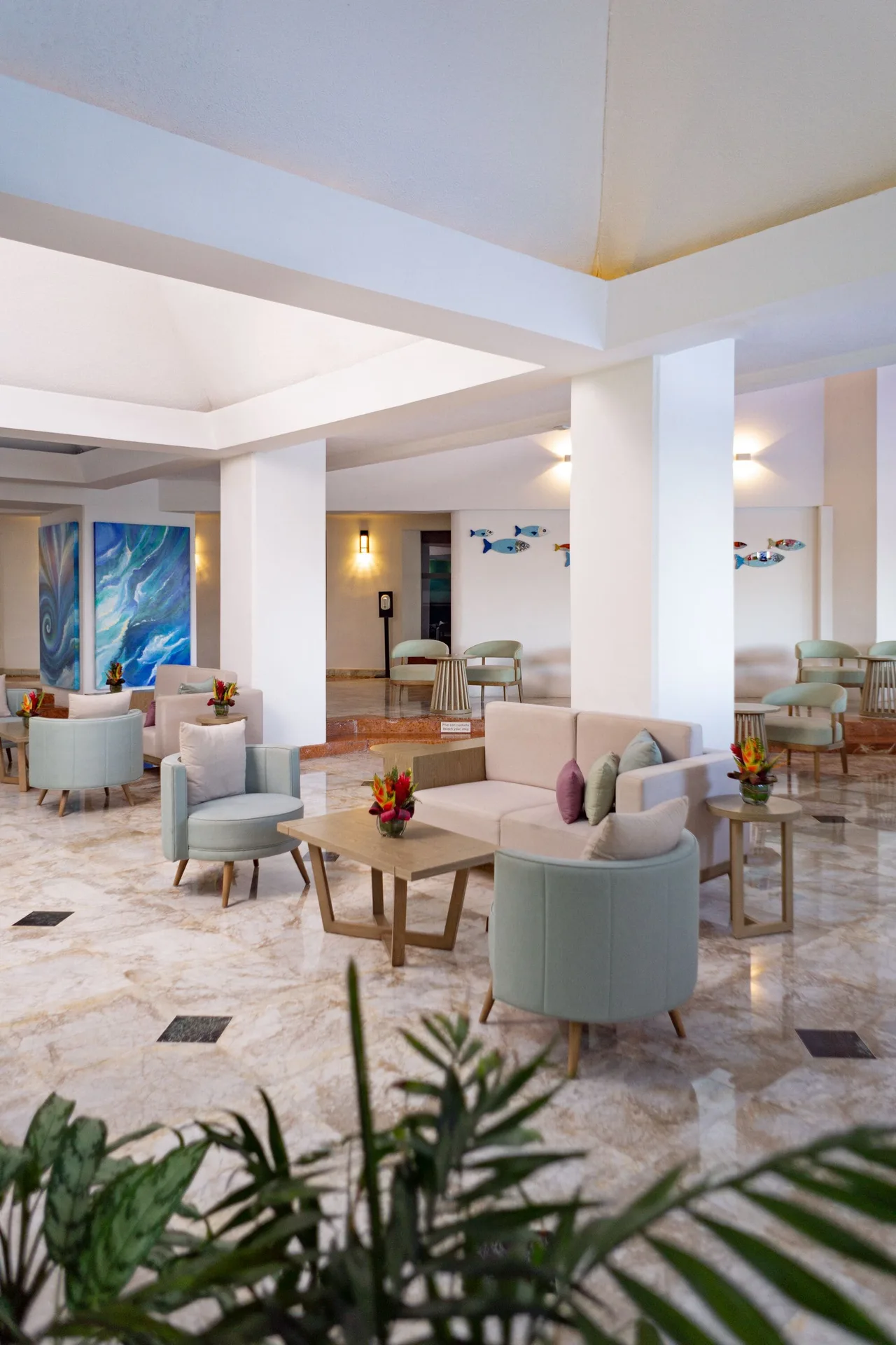 Spacious lobby lounge with sofas, chairs, plants, and wall art at Sunset Marina Resort & Yacht Club.