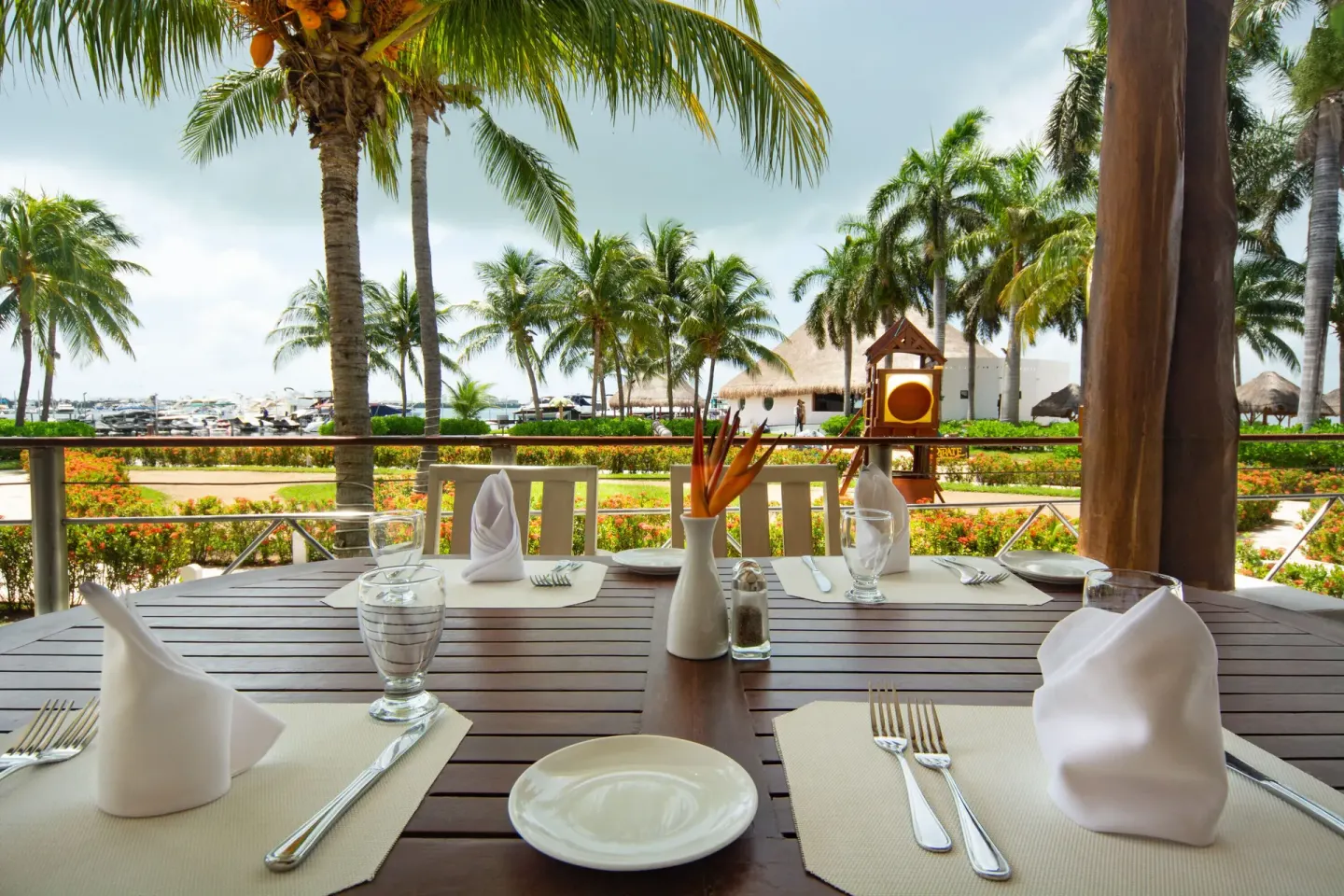 Terrace dining table with marina and palms at Sunset Marina Resort & Yacht Club.