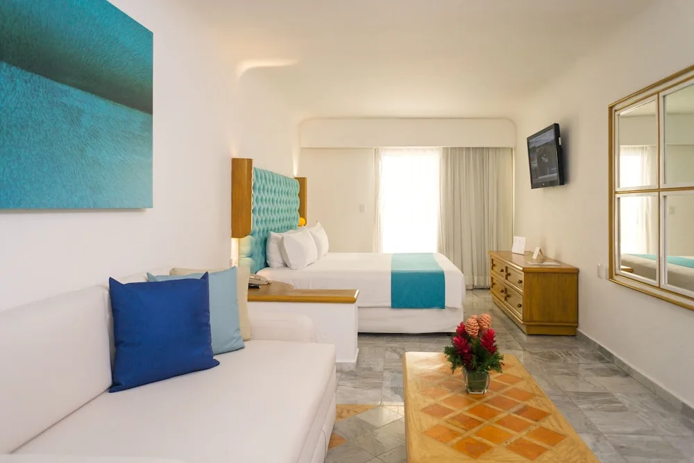 Studio room with king bed, sofa, dresser, and mirror at Sunset Marina Resort & Yacht Club.