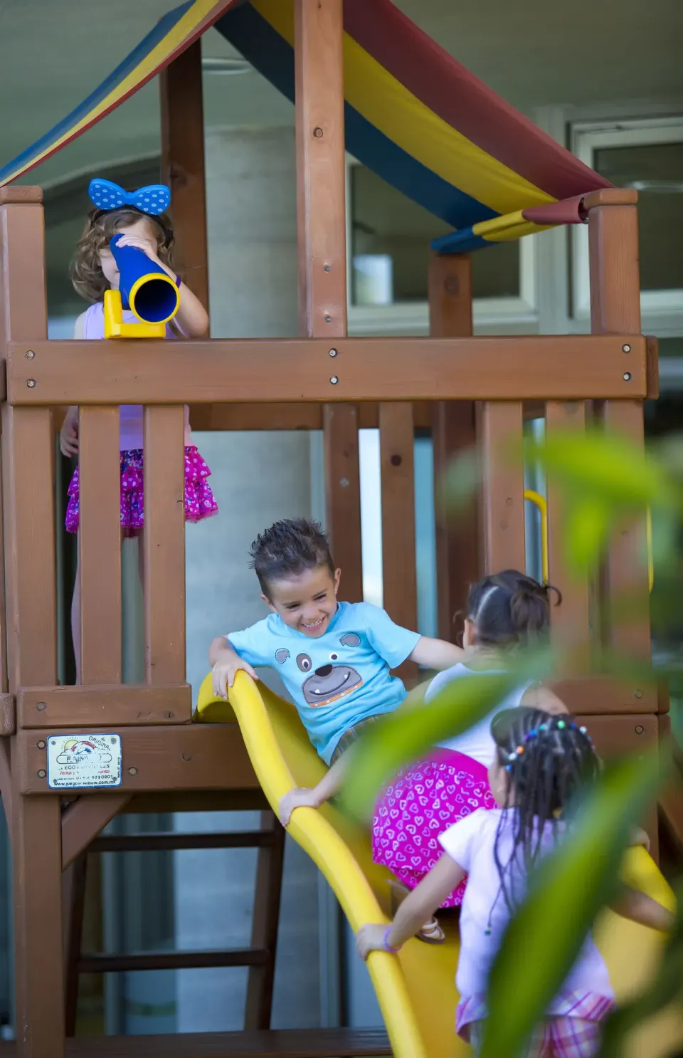 Children on a wooden playground slide at Sunset Plaza Beach Resort & Spa Pto Vallarta.