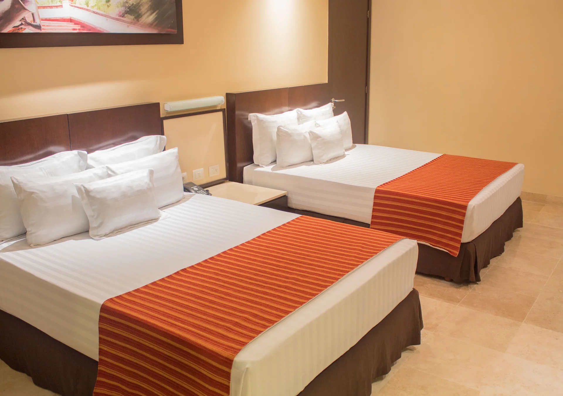 Guest room with two beds and orange runners at Sunset Plaza Beach Resort & Spa Pto Vallarta.