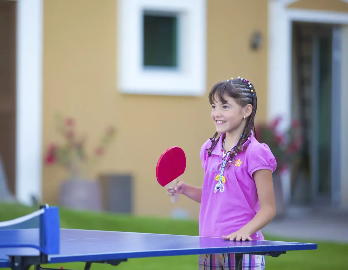 Child playing table tennis on the lawn at Sunset Plaza Beach Resort & Spa Pto Vallarta.
