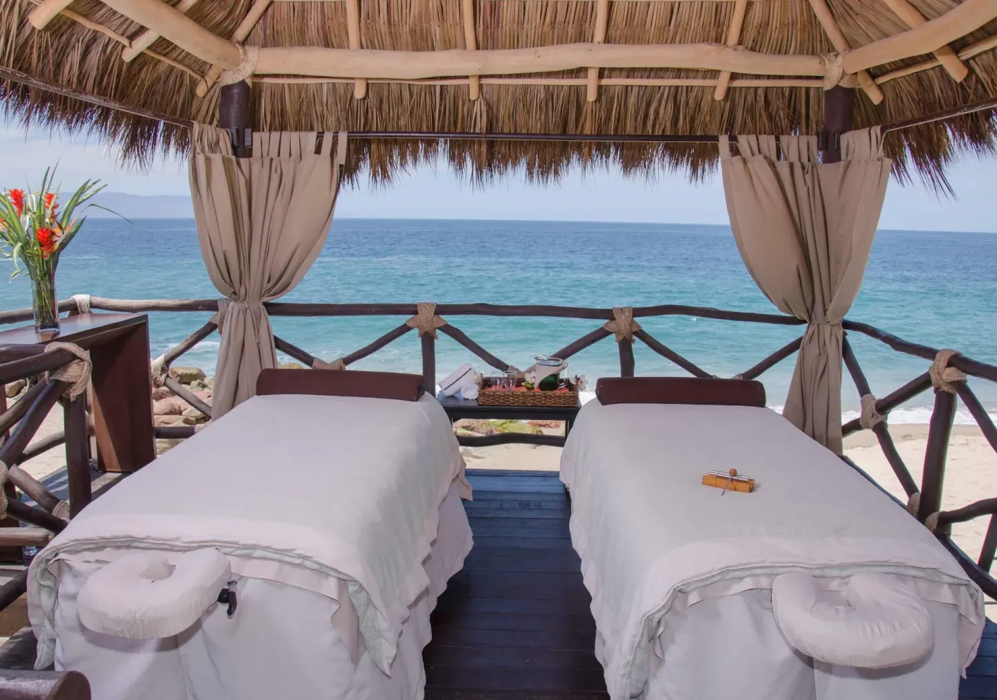 Oceanfront massage palapa with two tables at Sunset Plaza Beach Resort & Spa Pto Vallarta.