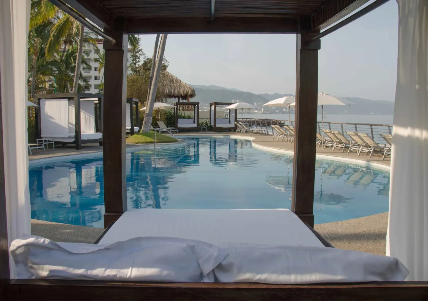Poolside daybed facing the ocean at Sunset Plaza Beach Resort & Spa Pto Vallarta.
