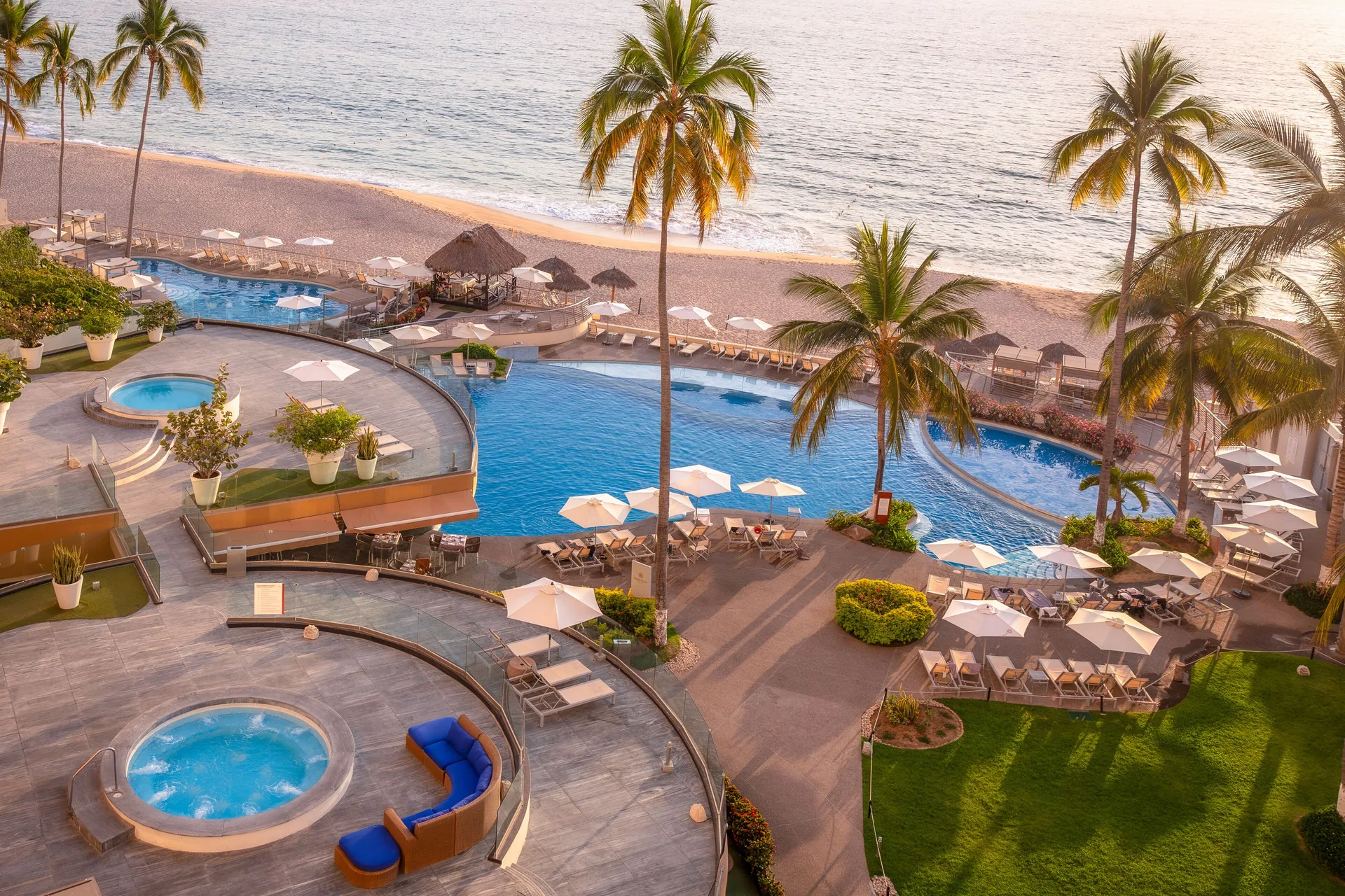 Sunlit pool terraces and beach at Sunset Plaza Beach Resort & Spa Pto Vallarta.