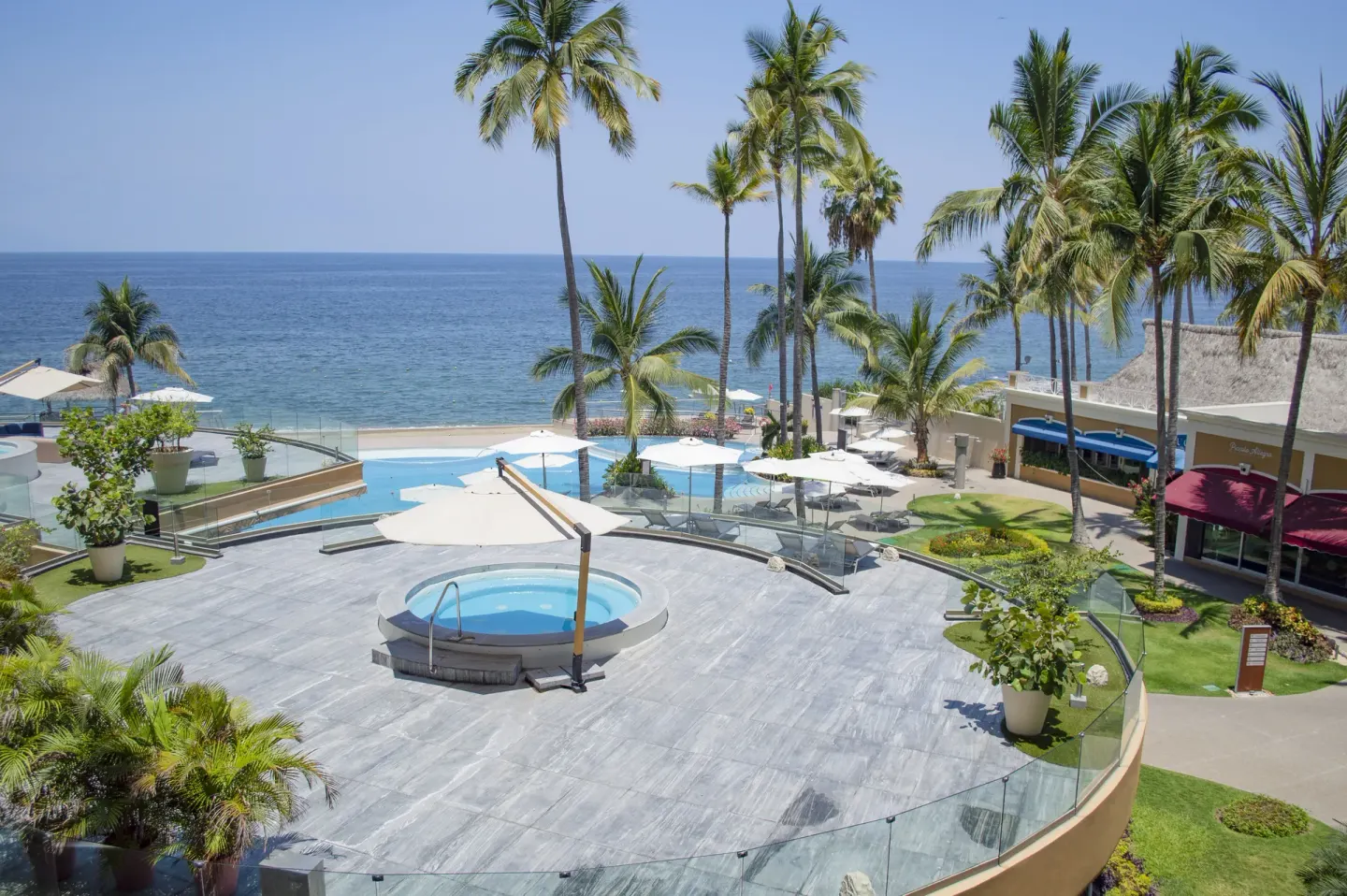 Terrace whirlpool, pools, palms, and ocean at Sunset Plaza Beach Resort & Spa Pto Vallarta.