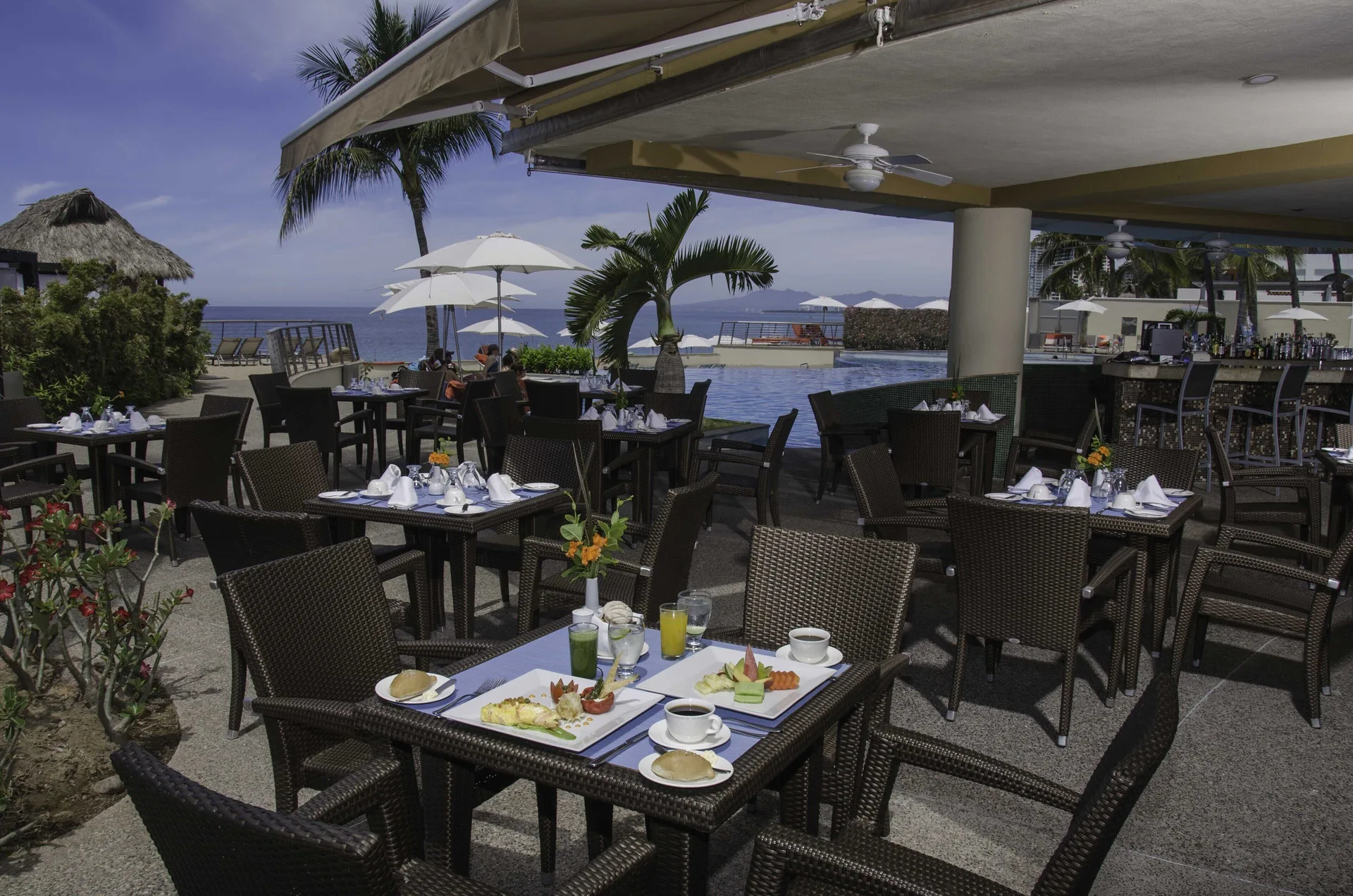 Poolside outdoor dining terrace at Sunset Plaza Beach Resort & Spa Pto Vallarta.