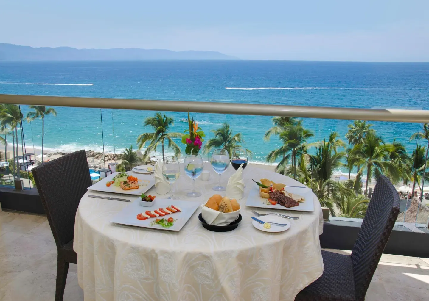 Deluxe Ocean Front balcony table overlooking the ocean at Sunset Plaza Beach Resort & Spa Pto Vallarta.