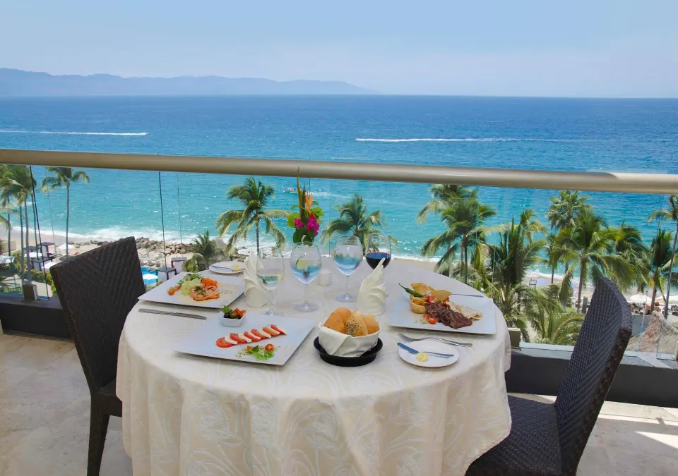 Deluxe Ocean Front balcony table overlooking the ocean at Sunset Plaza Beach Resort & Spa Pto Vallarta.