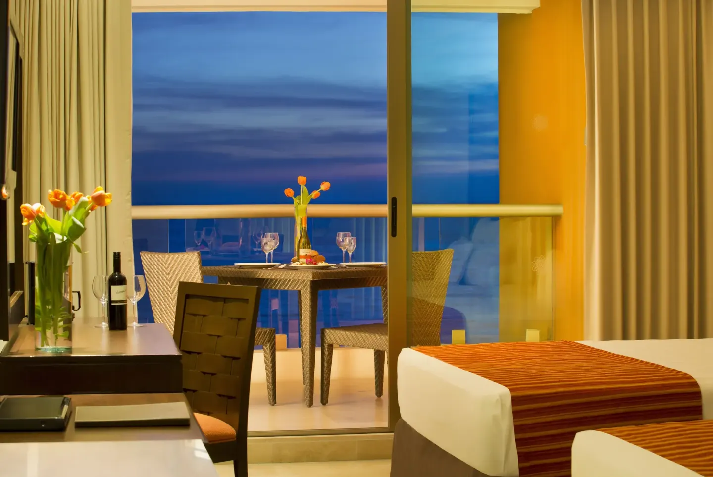 Deluxe Ocean Front room balcony dining setup at Sunset Plaza Beach Resort & Spa Pto Vallarta.