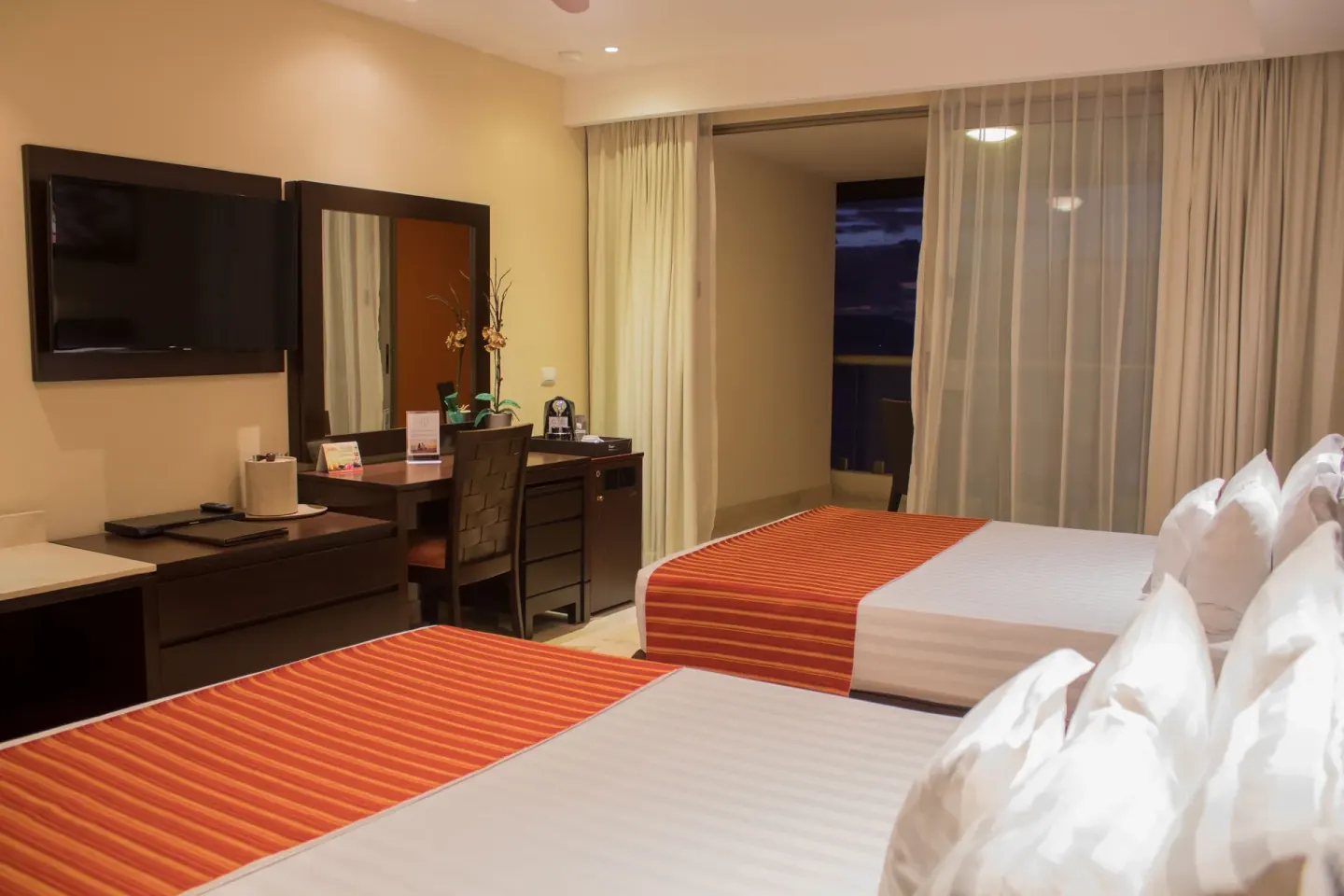 Deluxe Ocean Front room with two beds and desk at Sunset Plaza Beach Resort & Spa Pto Vallarta.
