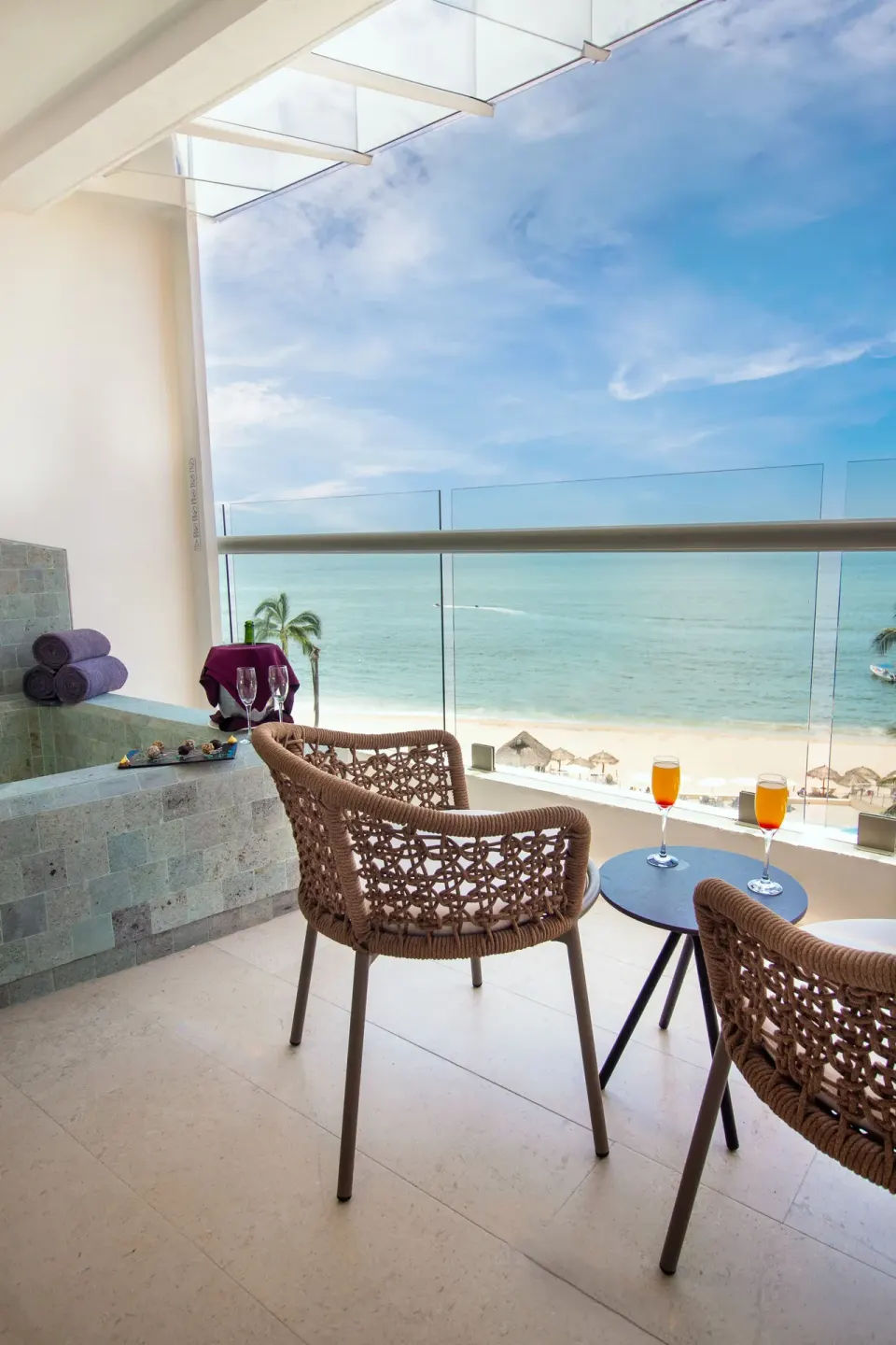 Balcony seating, stone tub, and beach view in Deluxe Premium Ocean Front at Sunset Plaza Beach Resort & Spa Pto Vallarta.