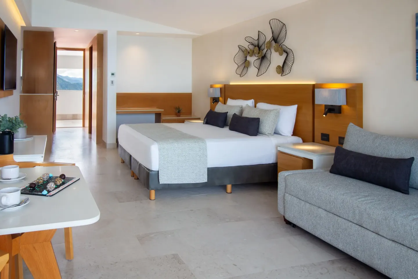 Deluxe Premium Ocean Front room with king bed and table setup at Sunset Plaza Beach Resort & Spa Pto Vallarta.