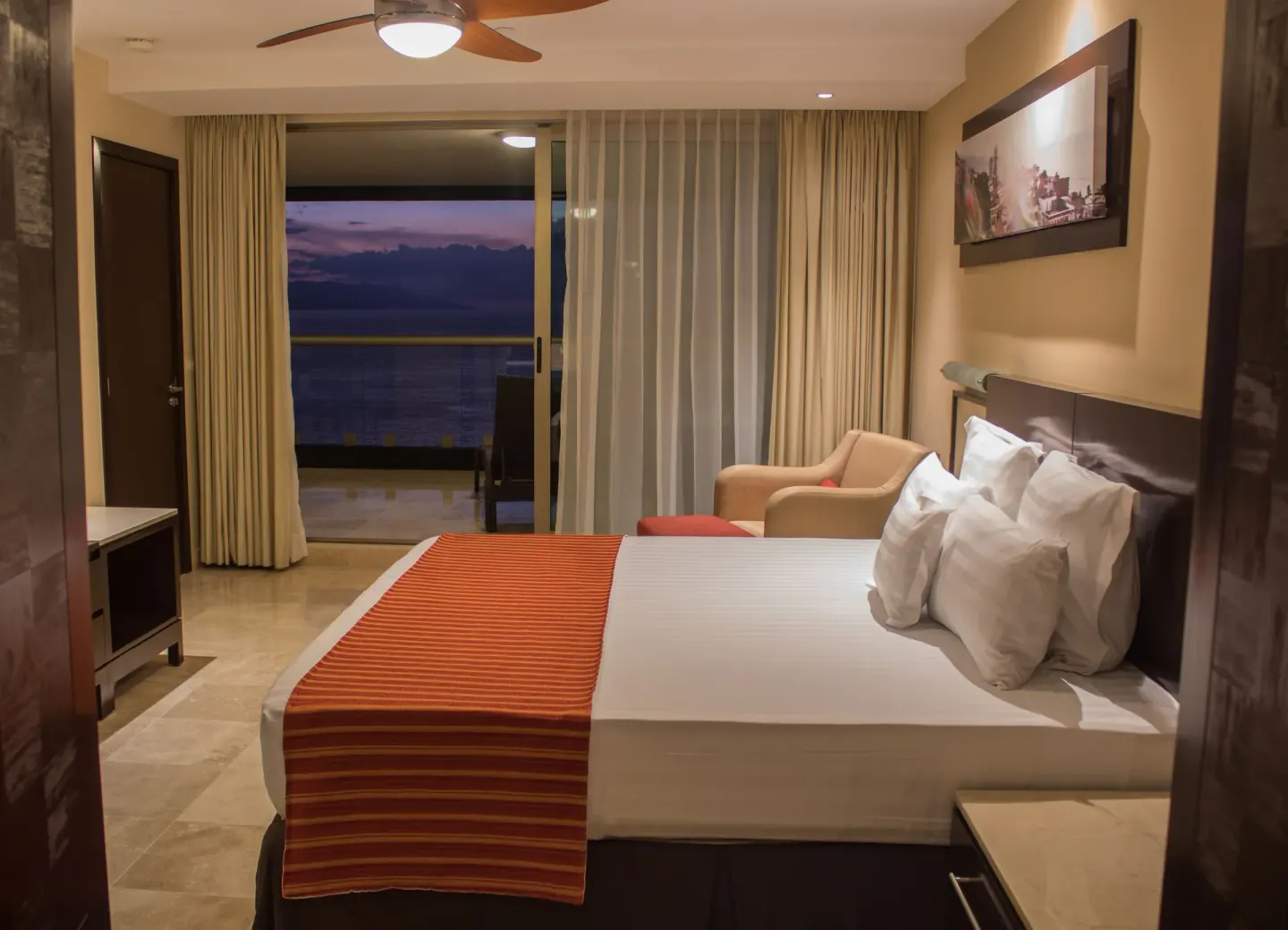 Oceanfront Suite king bed and balcony at Sunset Plaza Beach Resort & Spa Pto Vallarta.