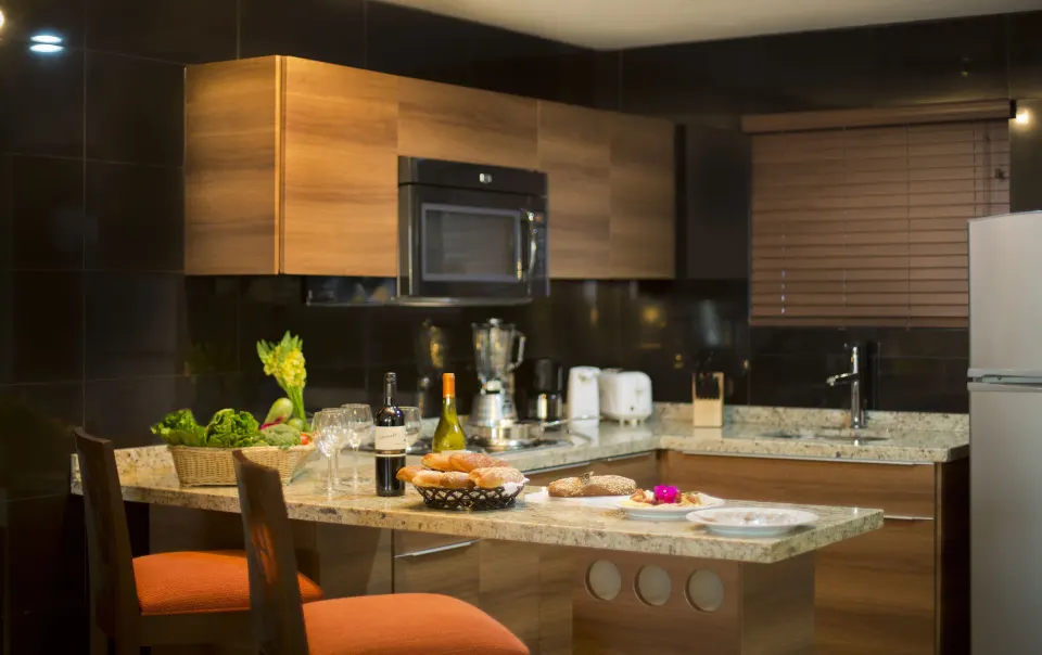 Oceanfront Suite kitchenette and dining chairs at Sunset Plaza Beach Resort & Spa Pto Vallarta.