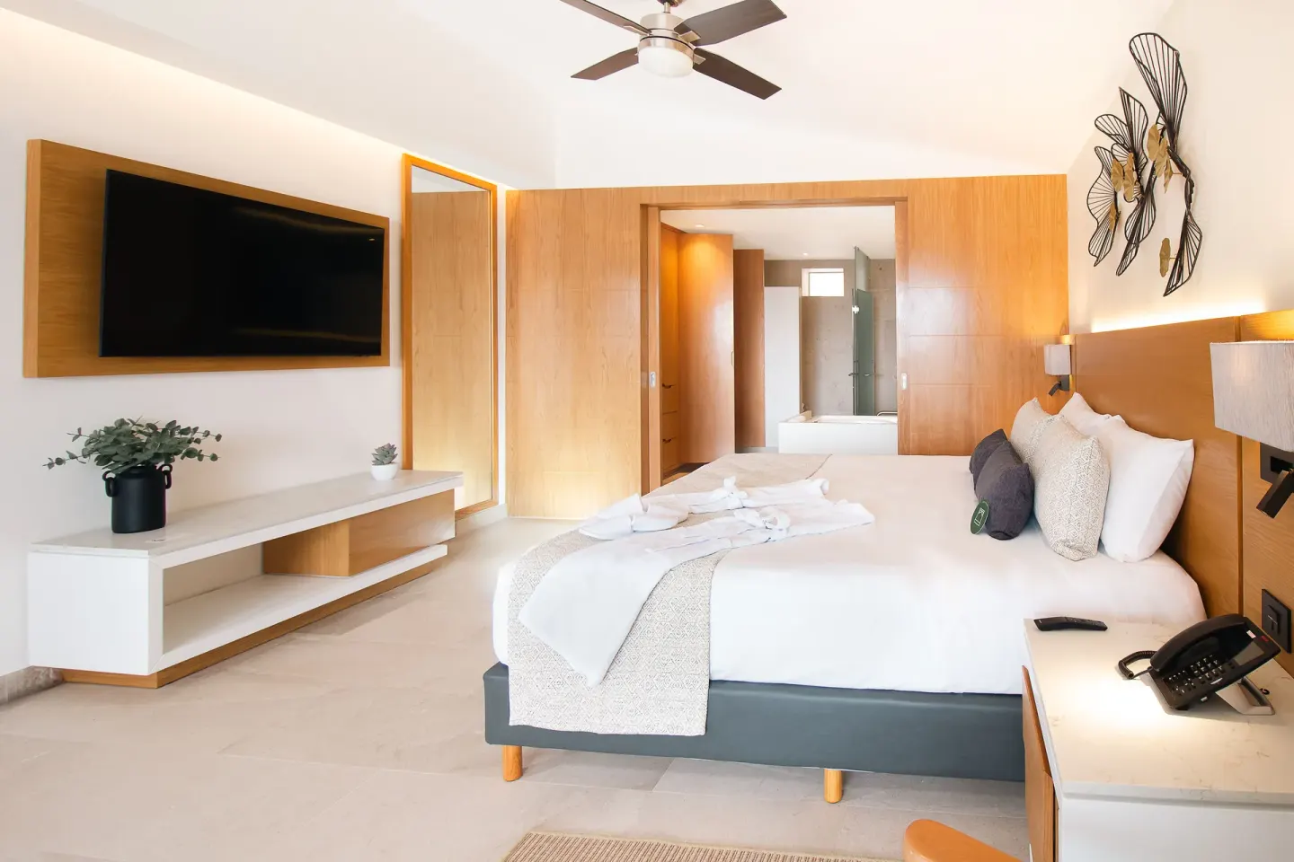 Suite Premium Ocean Front king bed and wall-mounted TV at Sunset Plaza Beach Resort & Spa Pto Vallarta.