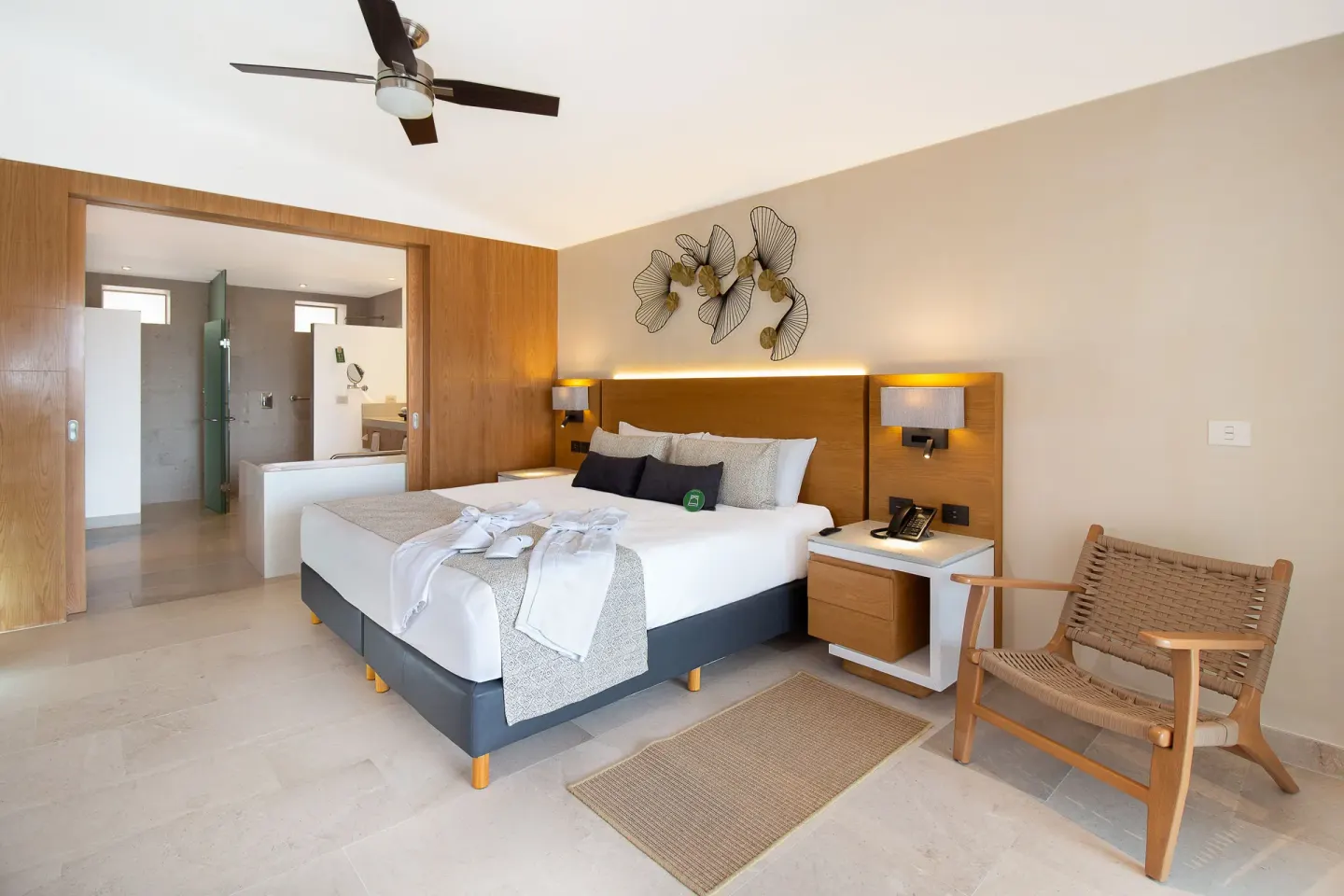 Suite Premium Ocean Front king bed with woven chair at Sunset Plaza Beach Resort & Spa Pto Vallarta.