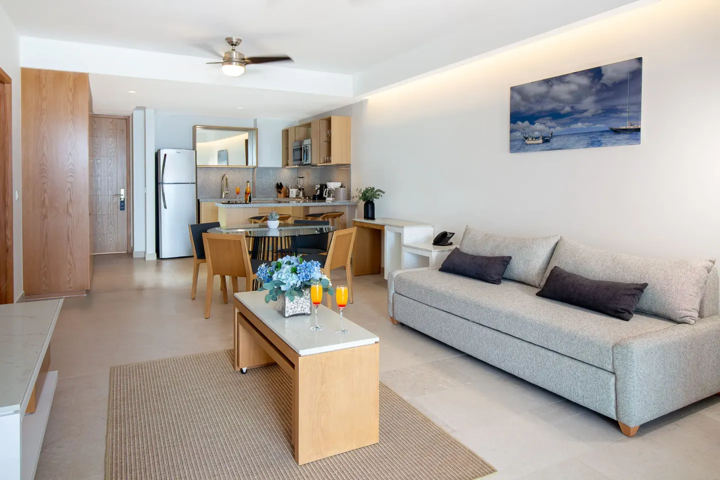 Premium Ocean Front suite lounge at Sunset Plaza Beach Resort & Spa Pto Vallarta with sofa, table, and kitchen.