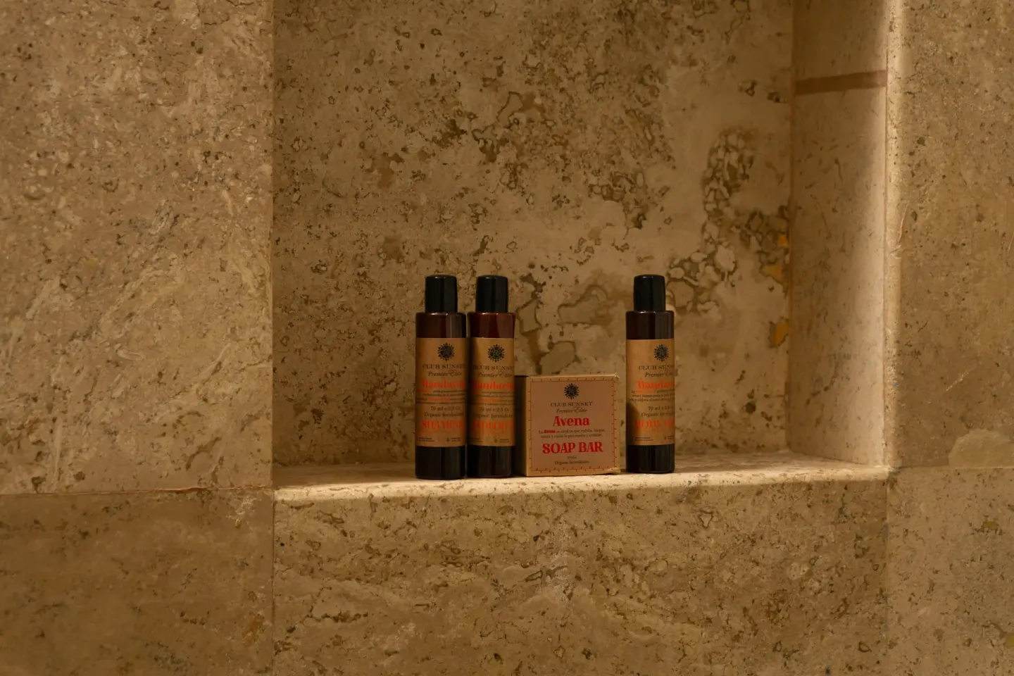 Bath amenities displayed in a stone shower niche at Sunset Royal Beach Resort.