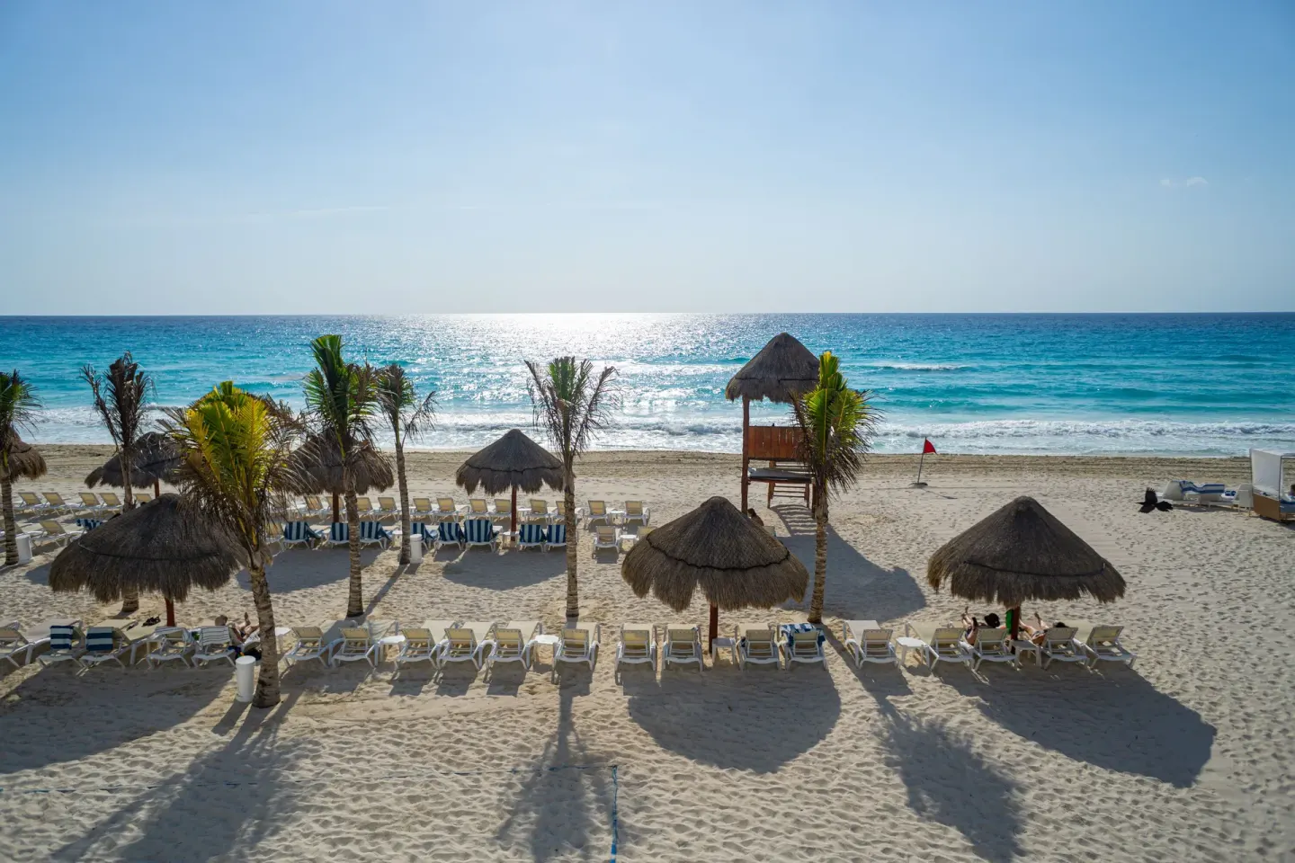 Beach loungers, palapas, and ocean view at Sunset Royal Beach Resort.