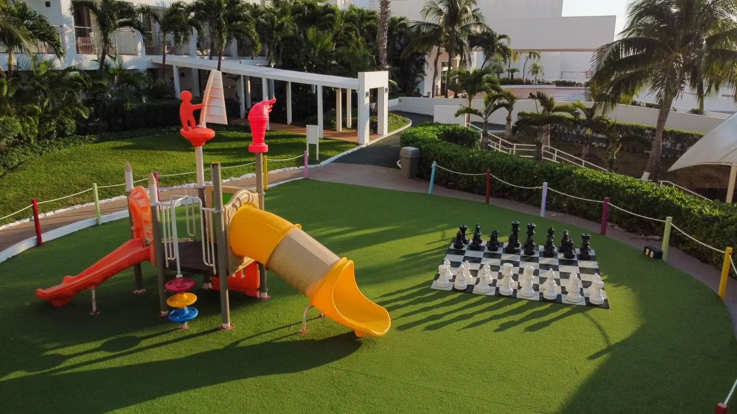 Children's play area with slides and oversized chess at Sunset Royal Beach Resort.