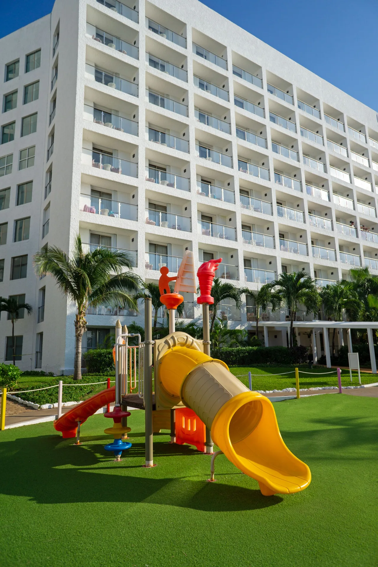 Colorful children’s play structure in front of the guestroom tower at Sunset Royal Beach Resort.