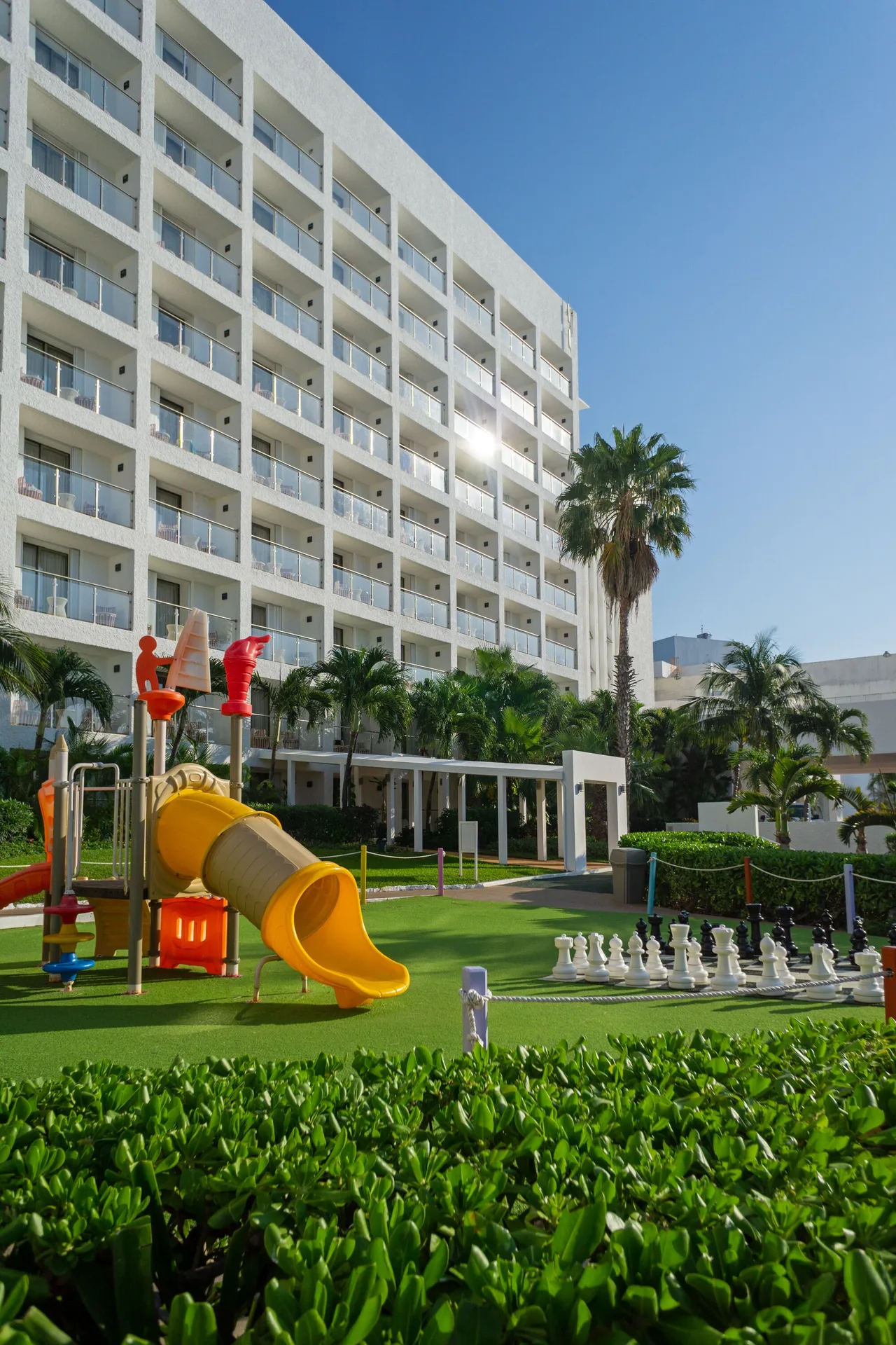 Garden play area with slide, chess set, and hotel balconies at Sunset Royal Beach Resort.