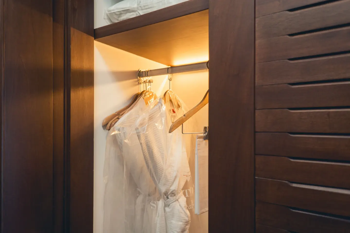 Guest room closet with robes and drawers at Sunset Royal Beach Resort.
