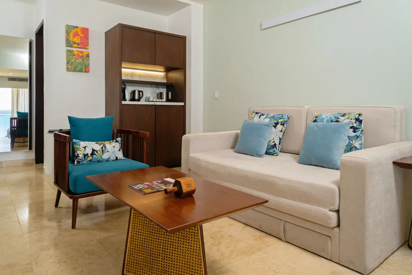 Guest suite lounge with sofa, armchair, coffee table, and wet bar at Sunset Royal Beach Resort.