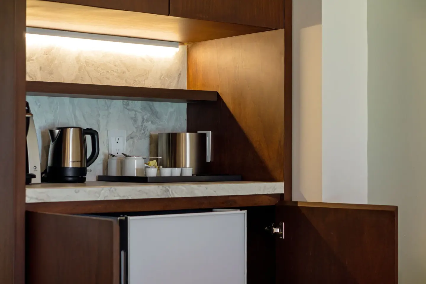 In-room beverage cabinet with kettle and mini fridge at Sunset Royal Beach Resort.