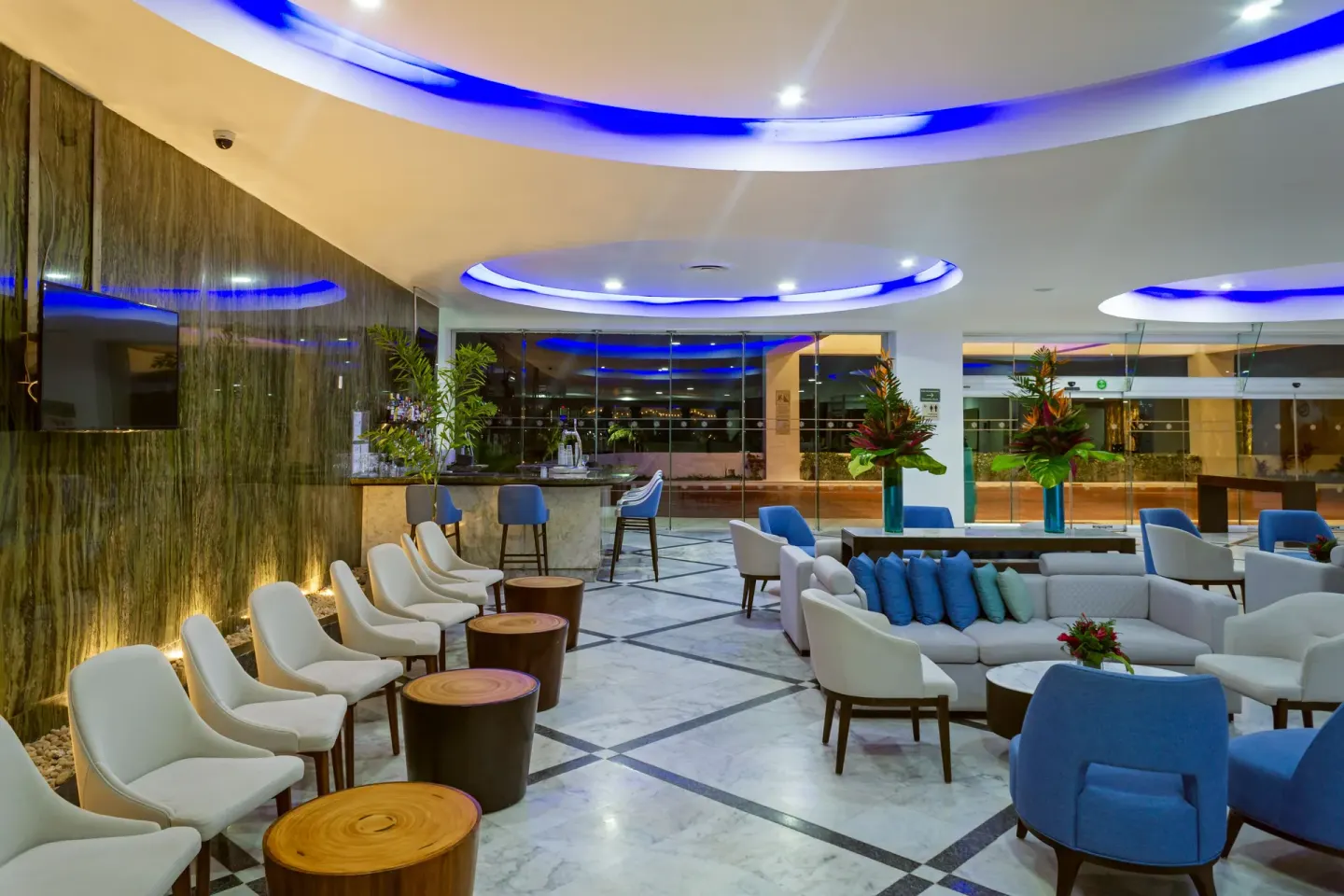 Modern lounge seating with blue ceiling lights at Sunset Royal Beach Resort.