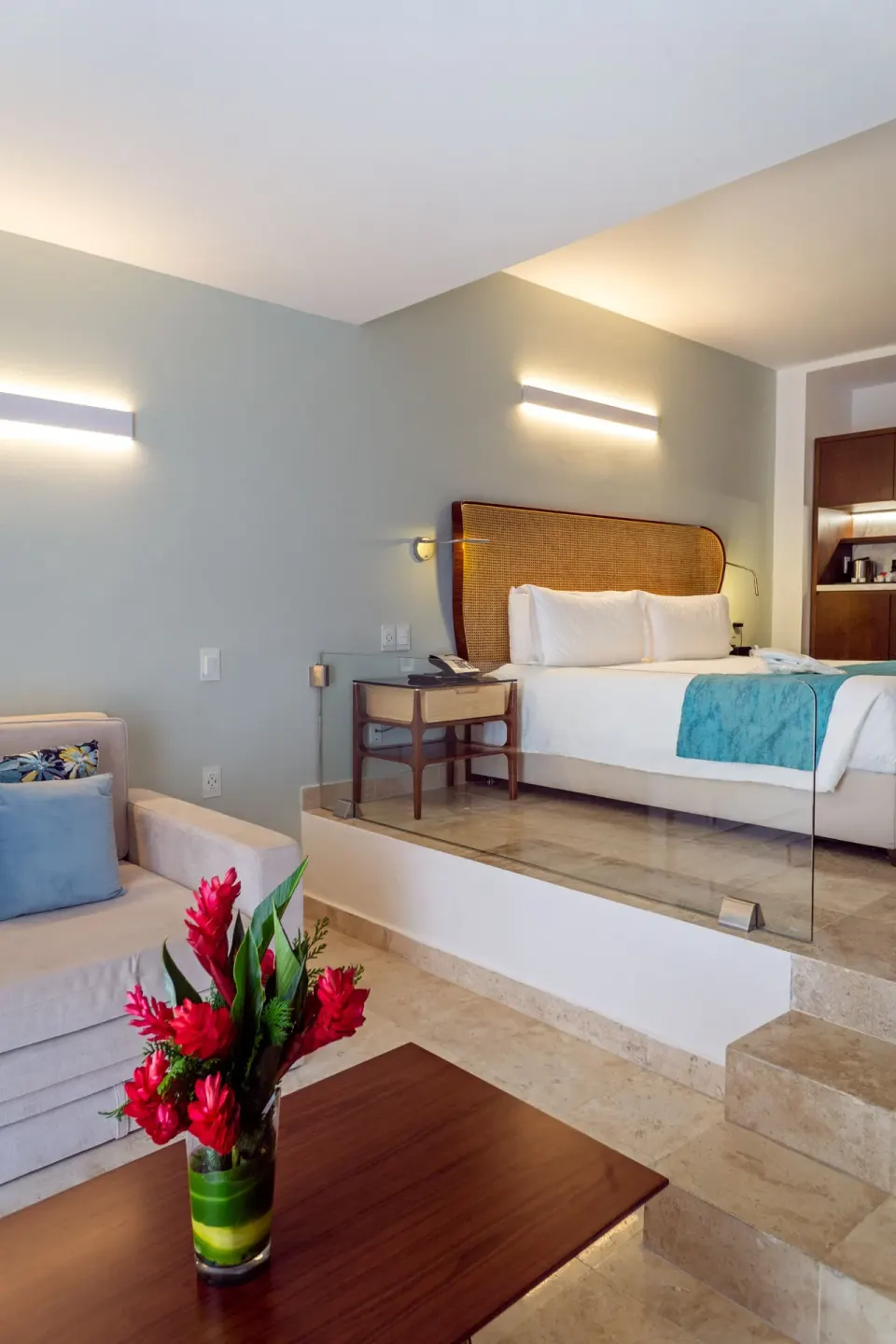 Split-level guest room with king bed and sitting area at Sunset Royal Beach Resort.