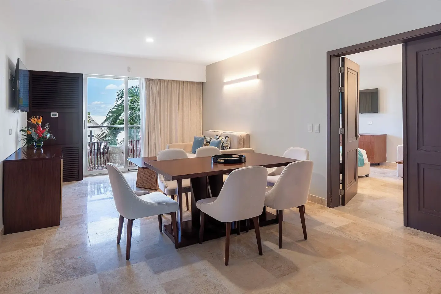 Suite living and dining area with balcony doors at Sunset Royal Beach Resort.