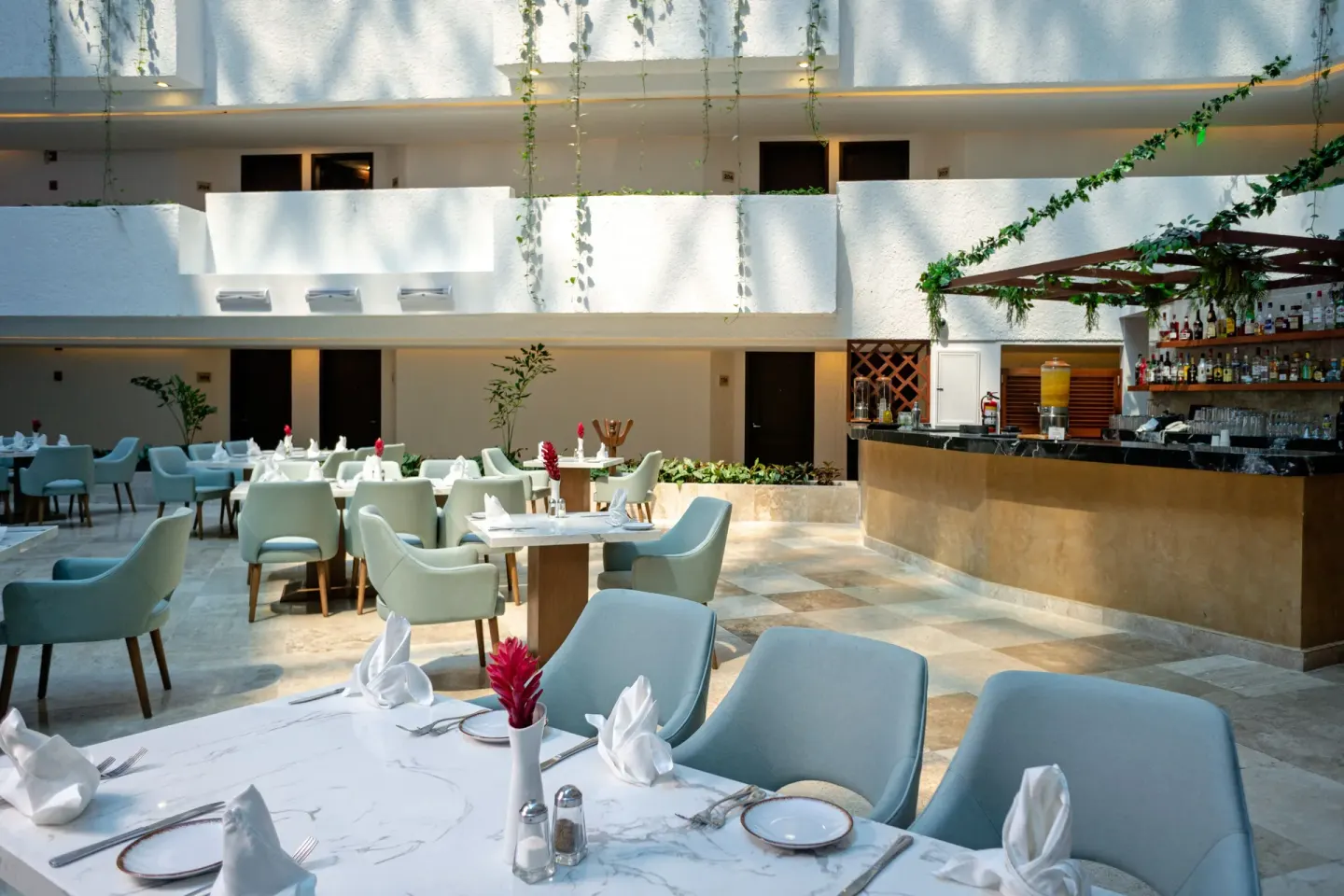 Open-air dining room with set tables and bar at Sunset Royal Beach Resort.