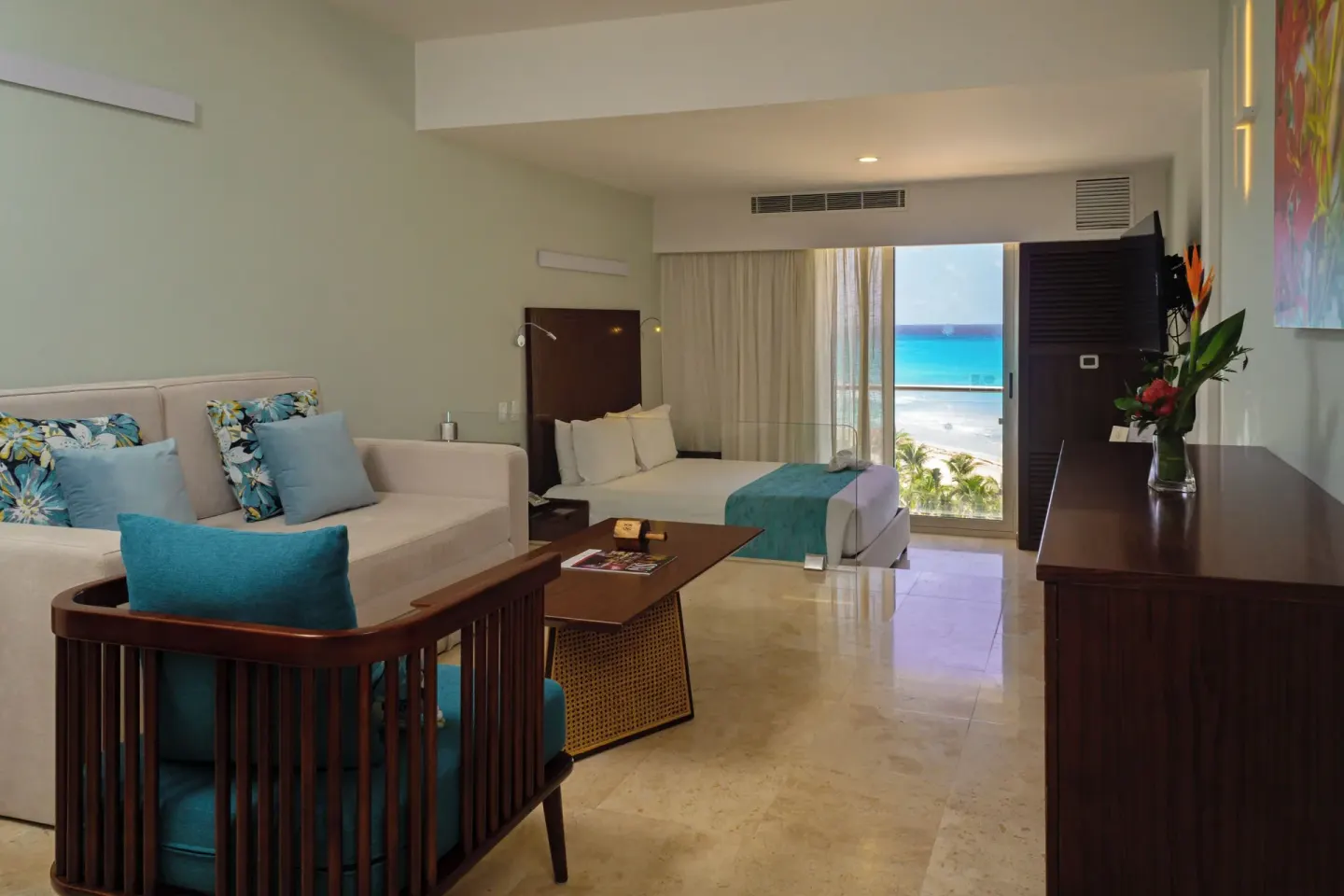Deluxe Ocean View room with seating area and bed at Sunset Royal Beach Resort.