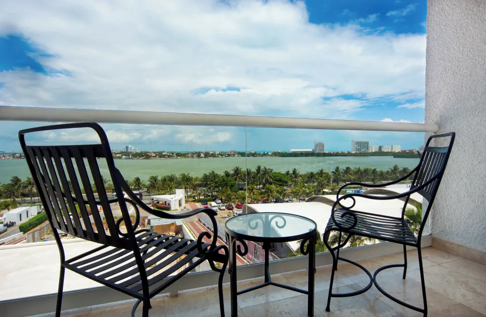 Family Room lagoon-view balcony with two chairs and a table at Sunset Royal Beach Resort.