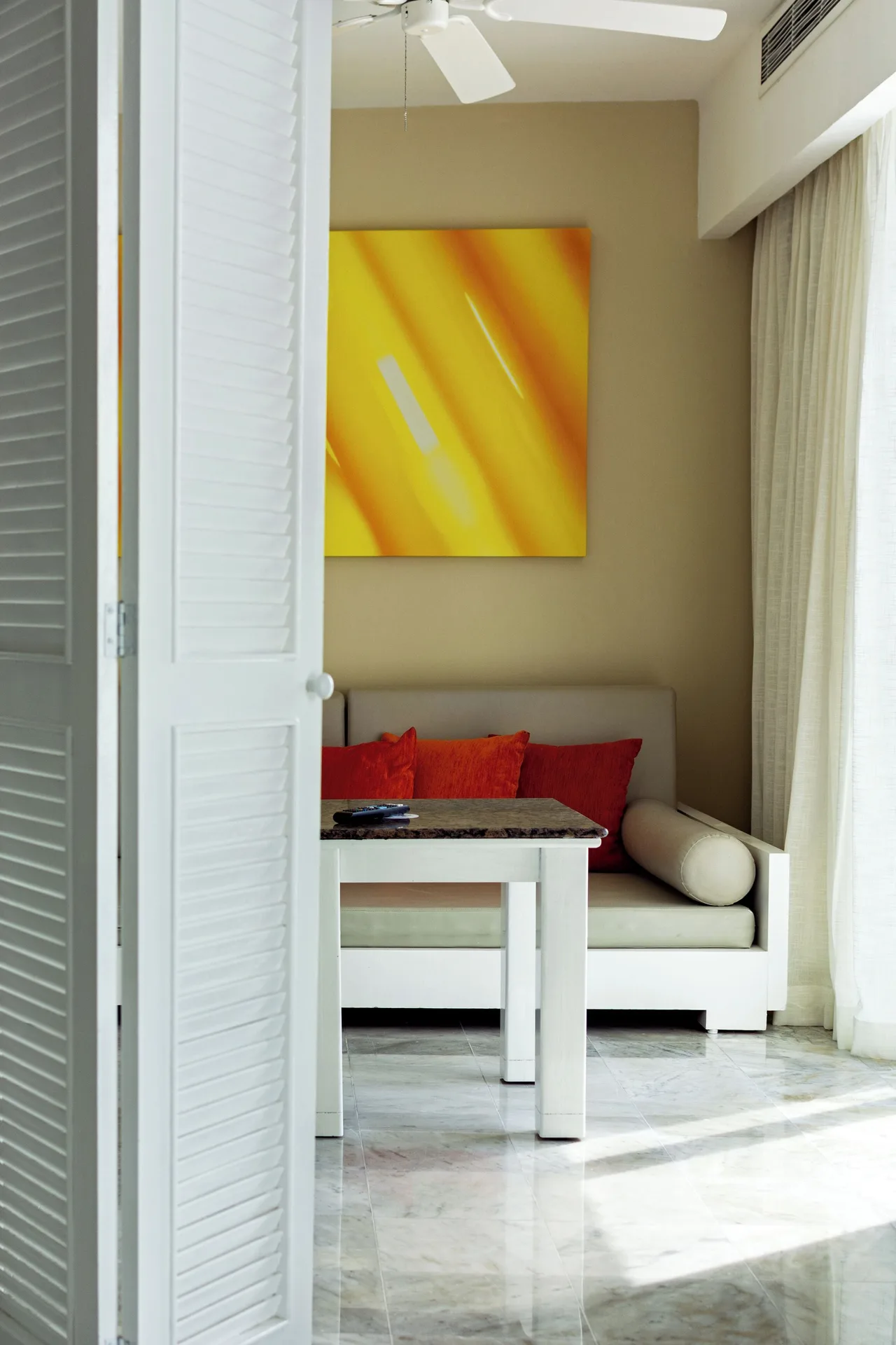 Family Room sitting nook with sofa, table, and bright wall art at Sunset Royal Beach Resort.