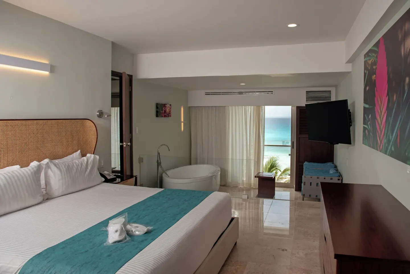 Family Room ocean view king bed and soaking tub at Sunset Royal Beach Resort.