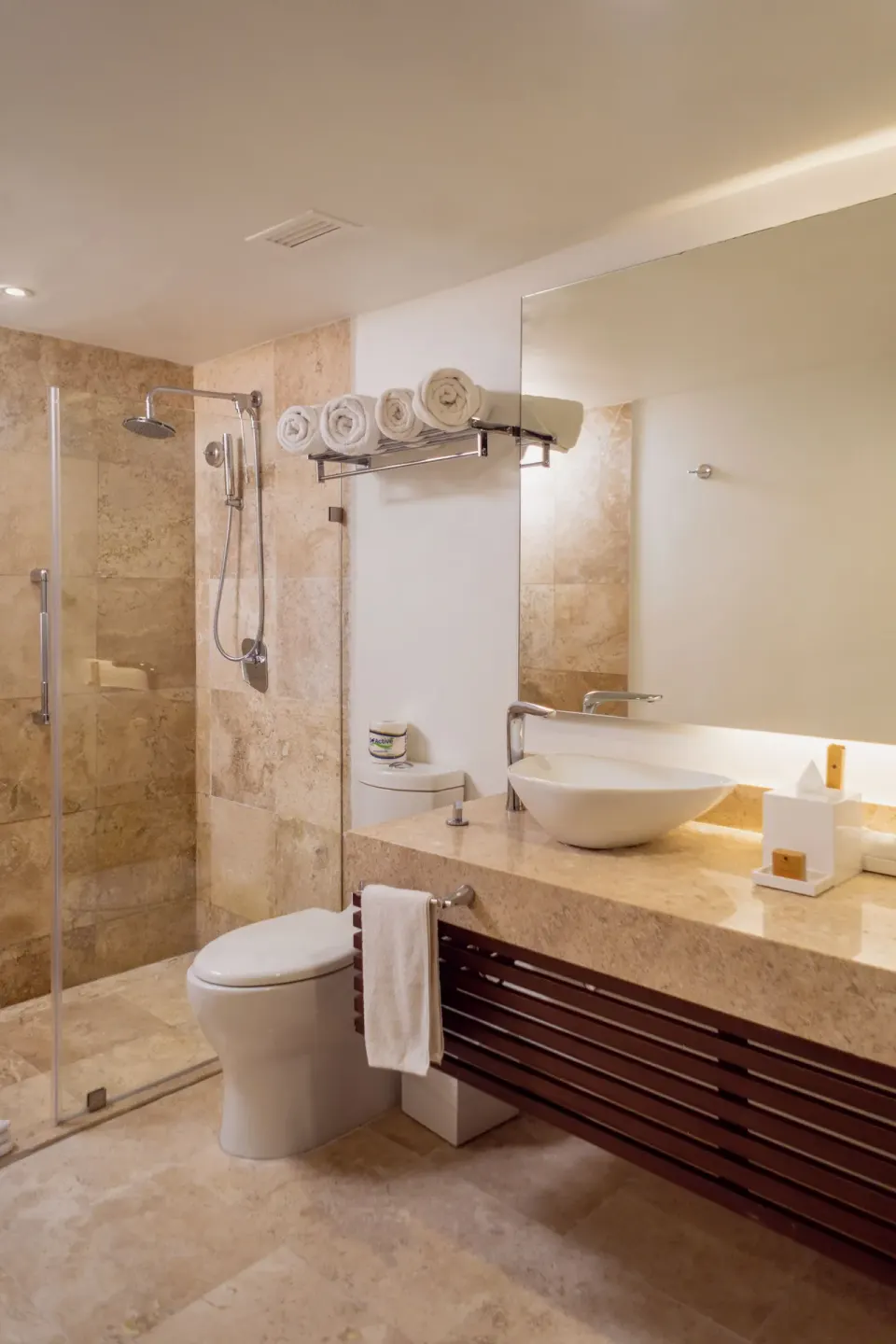 Standard Room bathroom with glass shower, toilet and vessel sink at Sunset Royal Beach Resort.