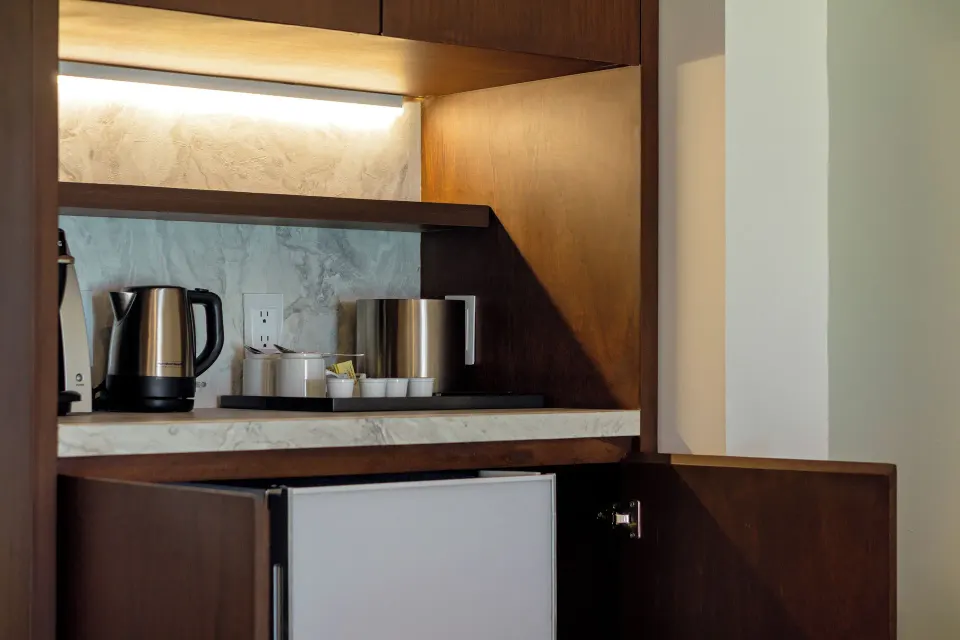 Standard Room refreshment cabinet with kettle, cups and mini fridge at Sunset Royal Beach Resort.