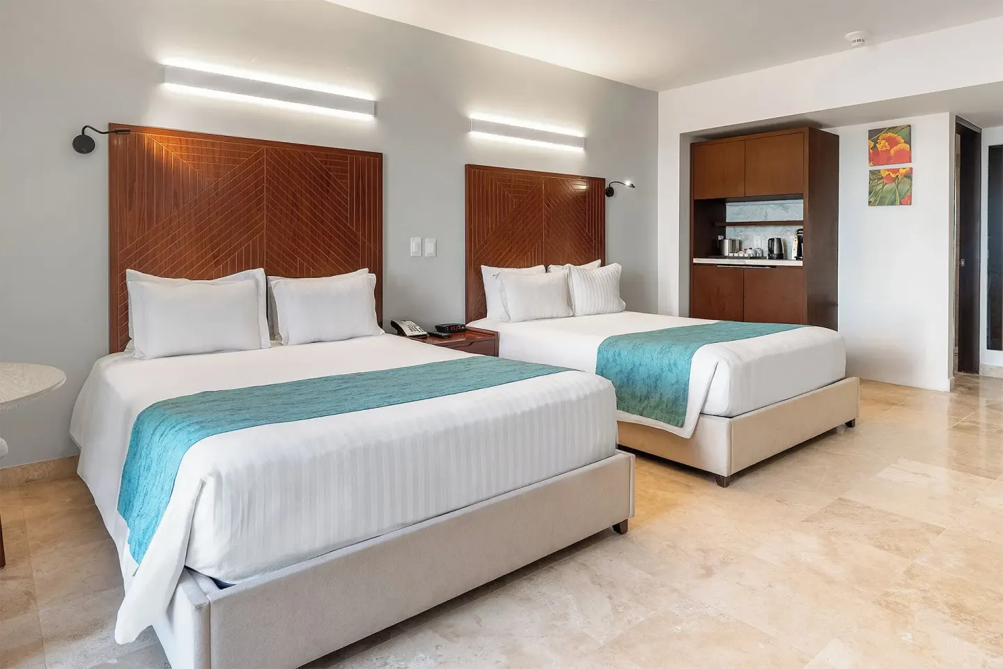 Standard Room with two beds, wood headboards and refreshment cabinet at Sunset Royal Beach Resort.
