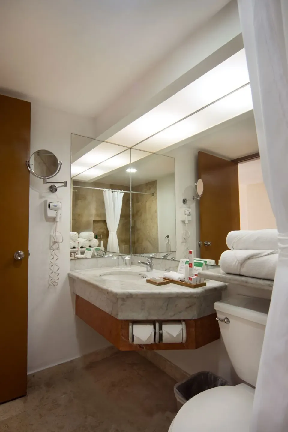 Studio bathroom vanity with mirror, towels and sink at Sunset Royal Beach Resort.