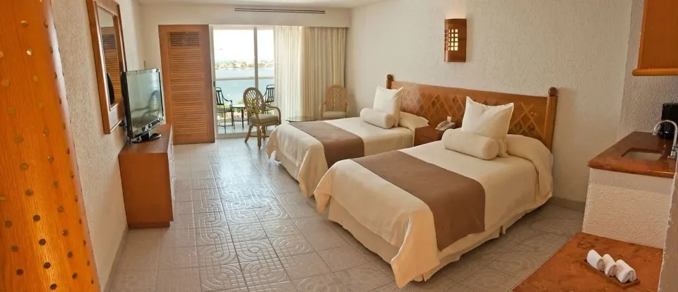Studio room with two beds, balcony seating and water view at Sunset Royal Beach Resort.