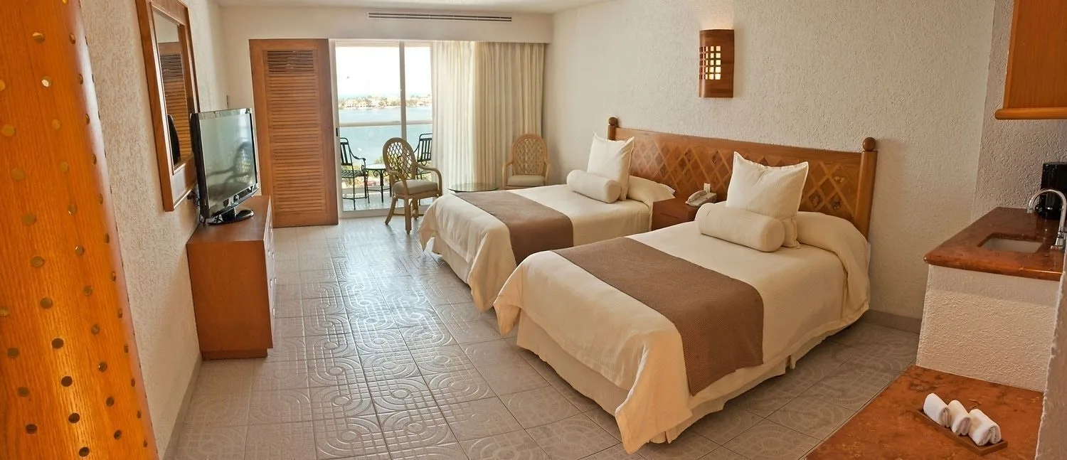 Studio room with two beds, balcony seating and water view at Sunset Royal Beach Resort.