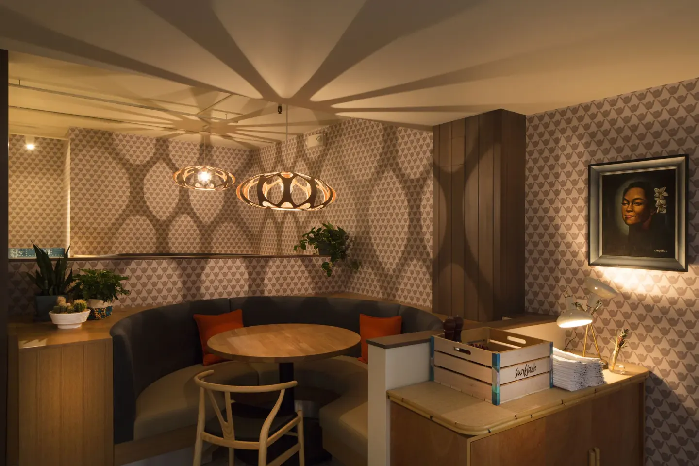 Curved banquette seating and pendant lights at Surfjack Hotel & Swim Club.
