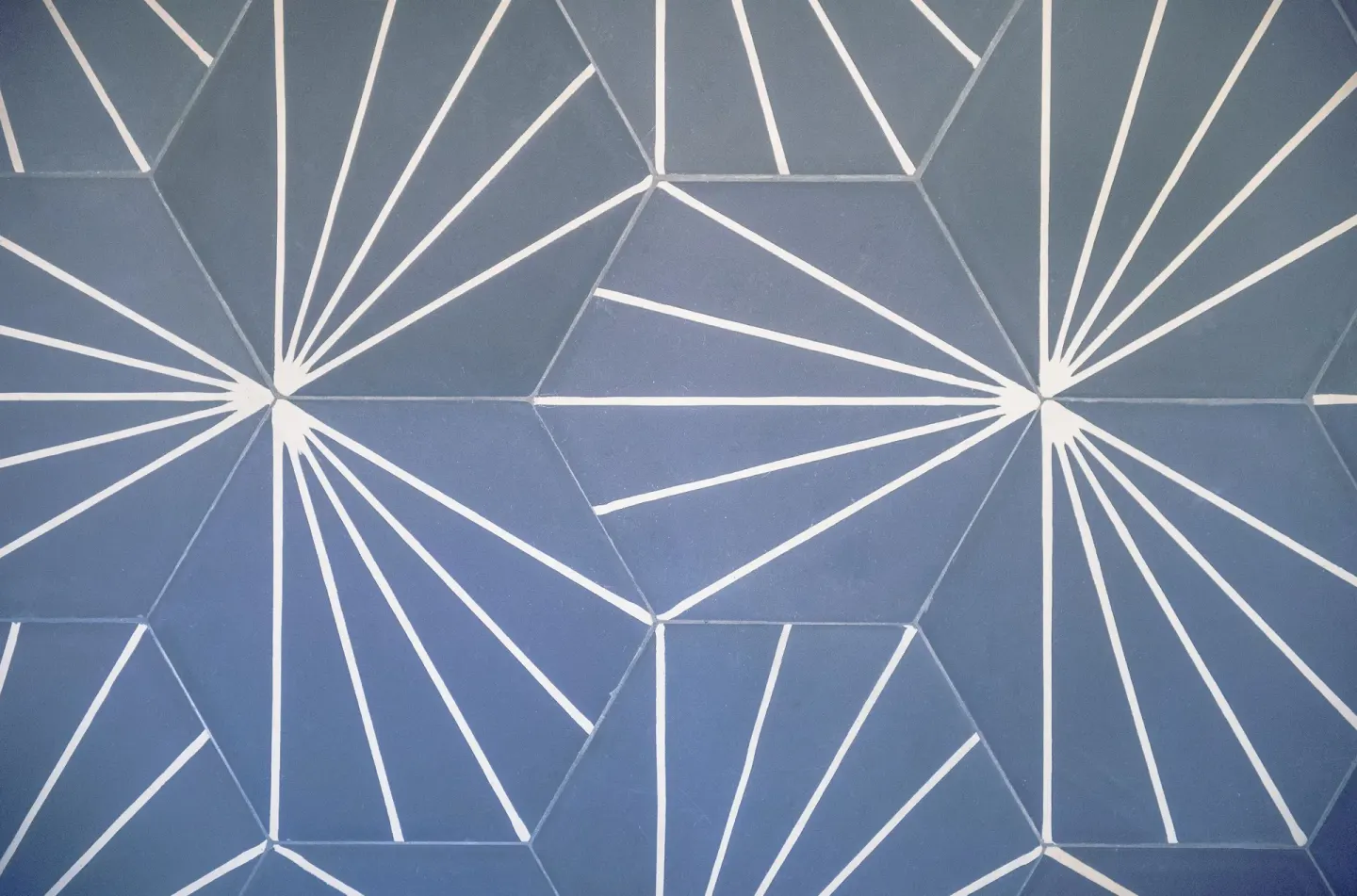Blue geometric wall pattern with white radiating lines at Surfjack Hotel & Swim Club.