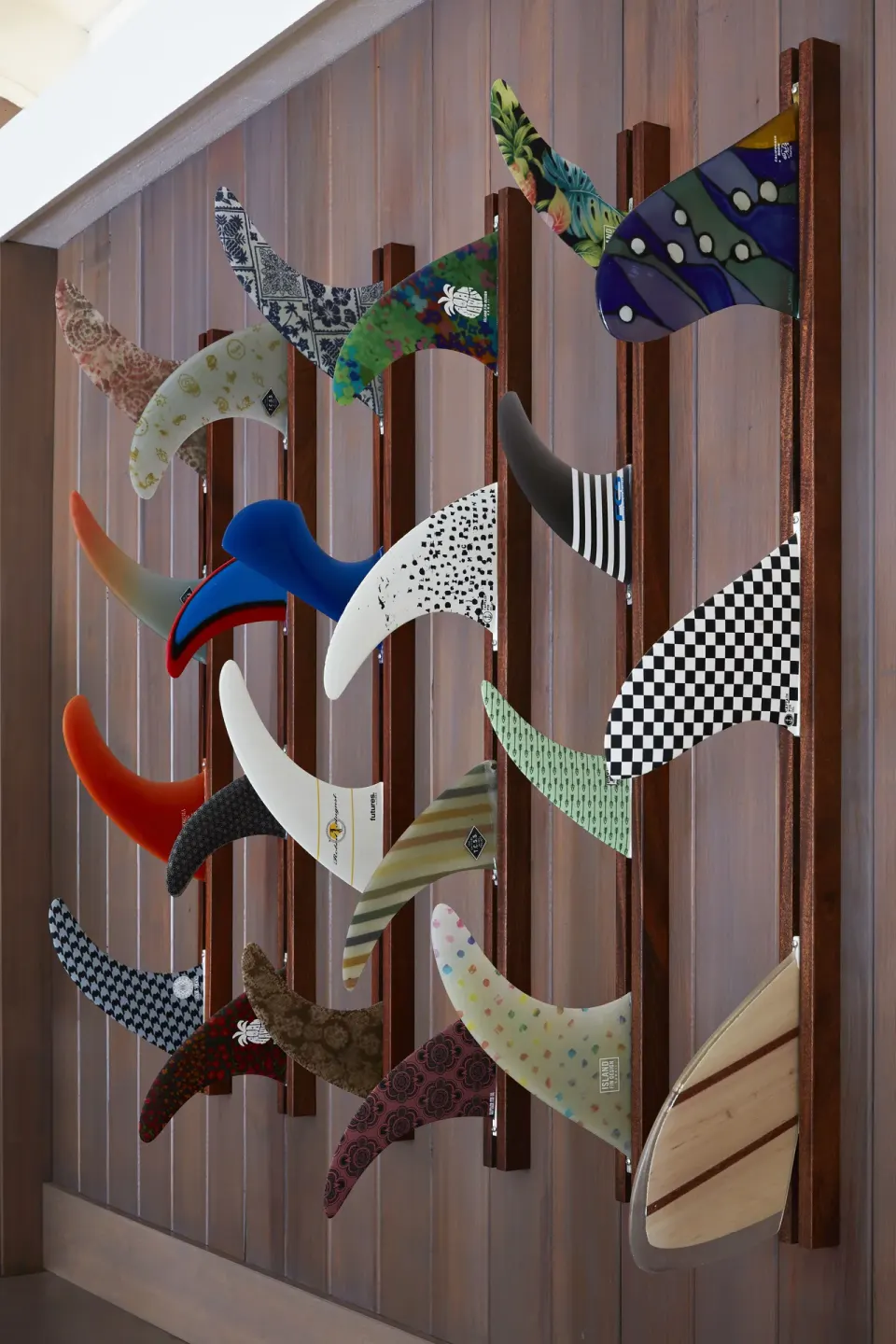 Wall-mounted surf fins in colorful patterns at Surfjack Hotel & Swim Club.